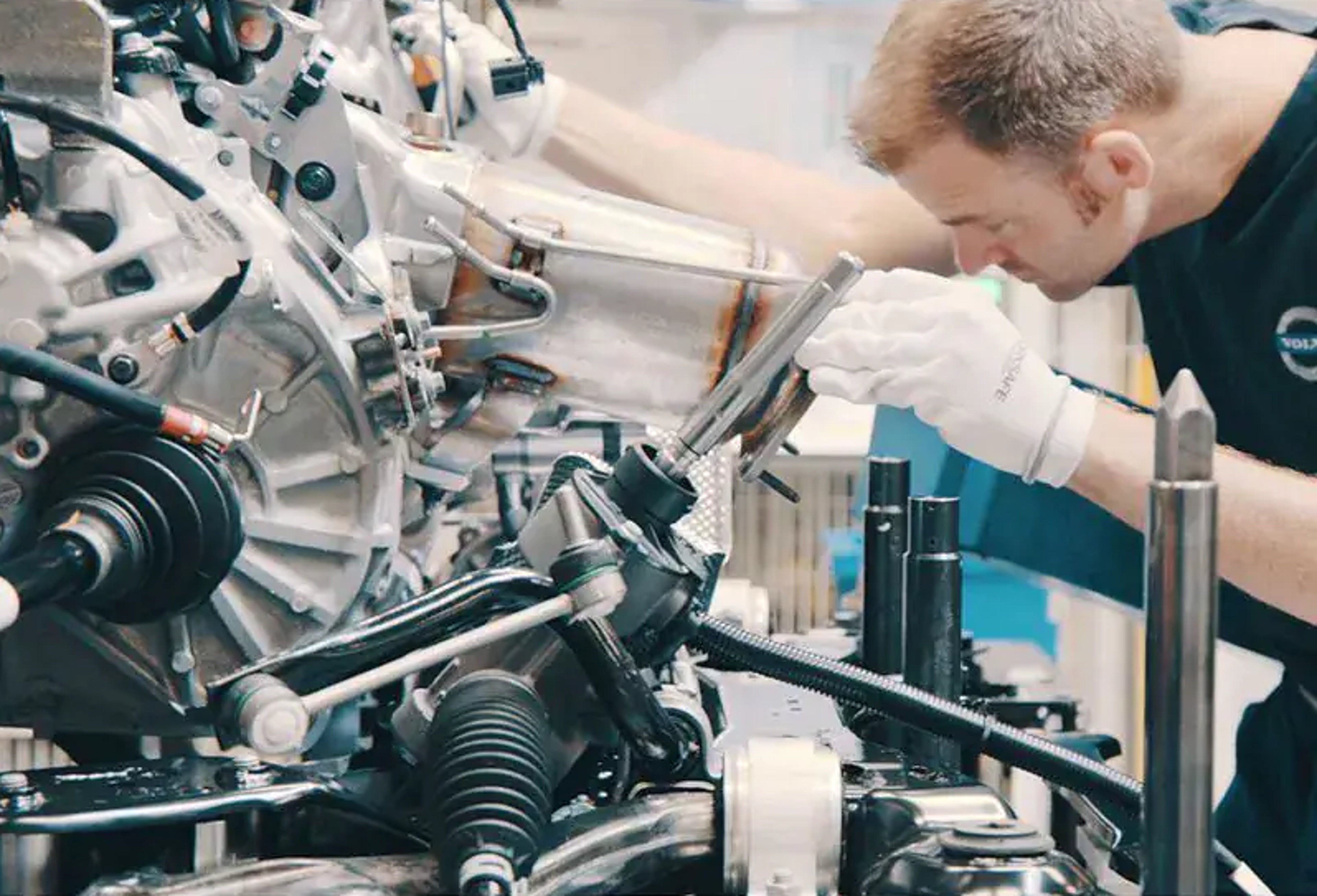 Ein männlicher Volvo Techniker arbeitet an einem offenen Elektromotor für einen Volvo.