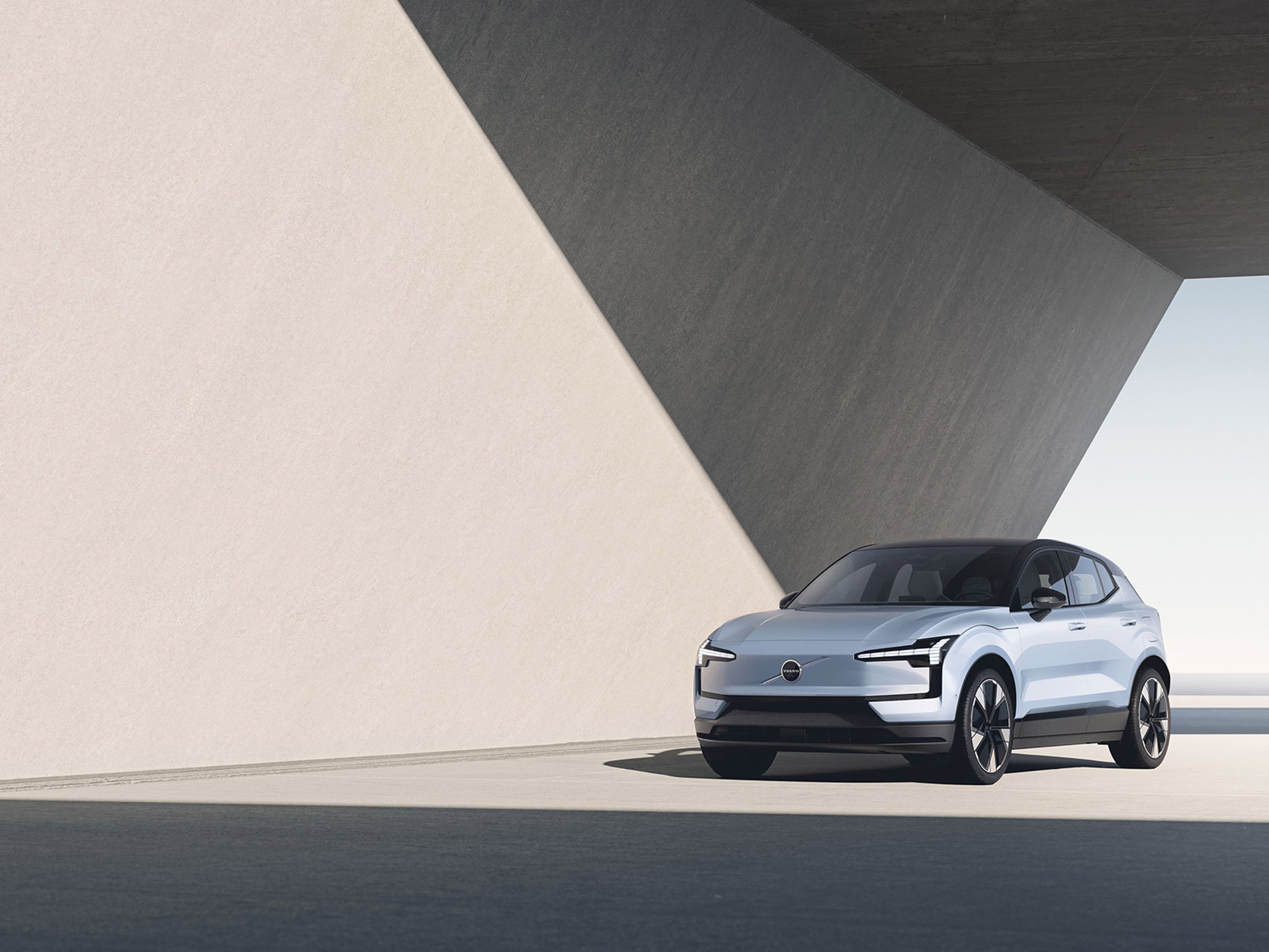 Blå EX30 från avstånd som står i ett sten garage