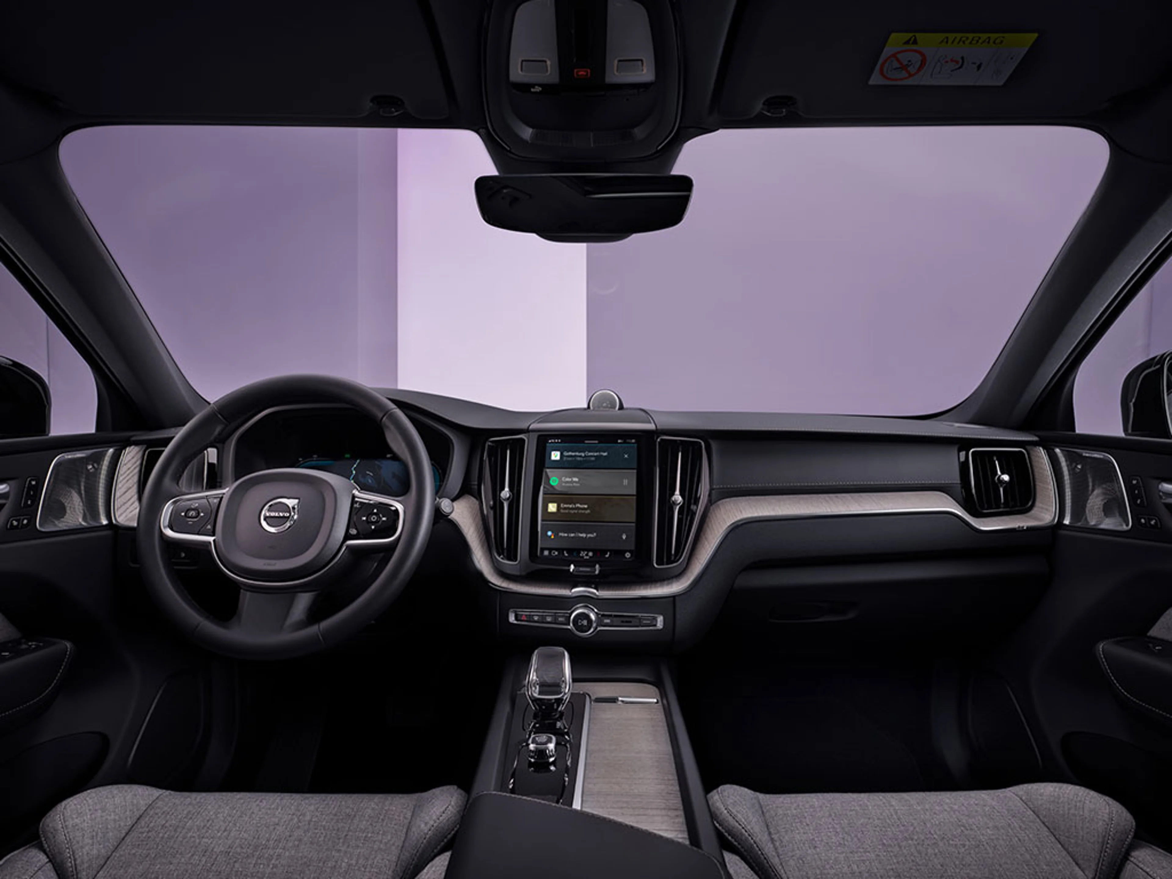 Vue intérieure d’une Volvo moderne avec volant, tableau de bord et écran tactile central.