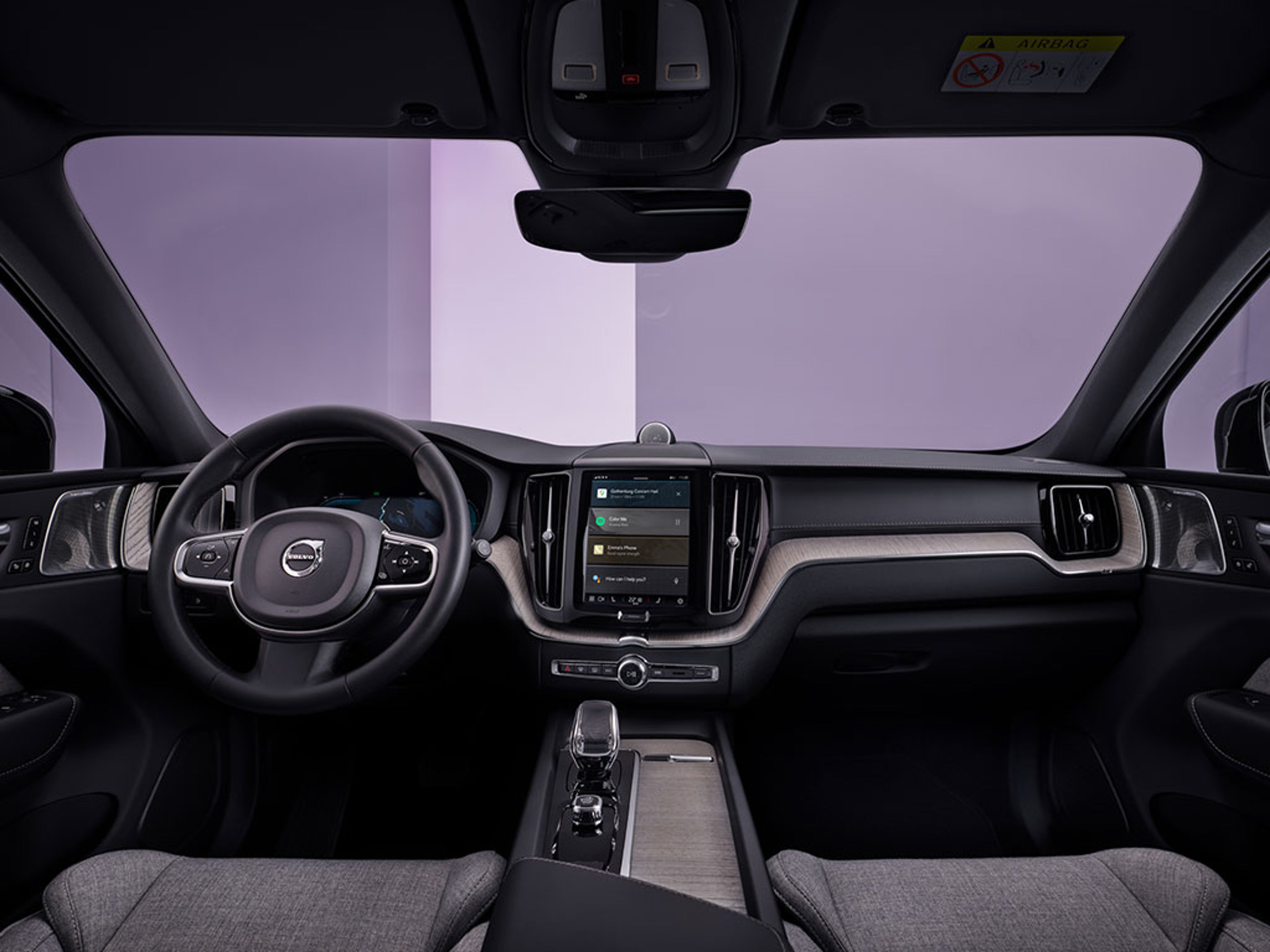 Vue intérieure d’une Volvo moderne avec volant, tableau de bord et écran tactile central.