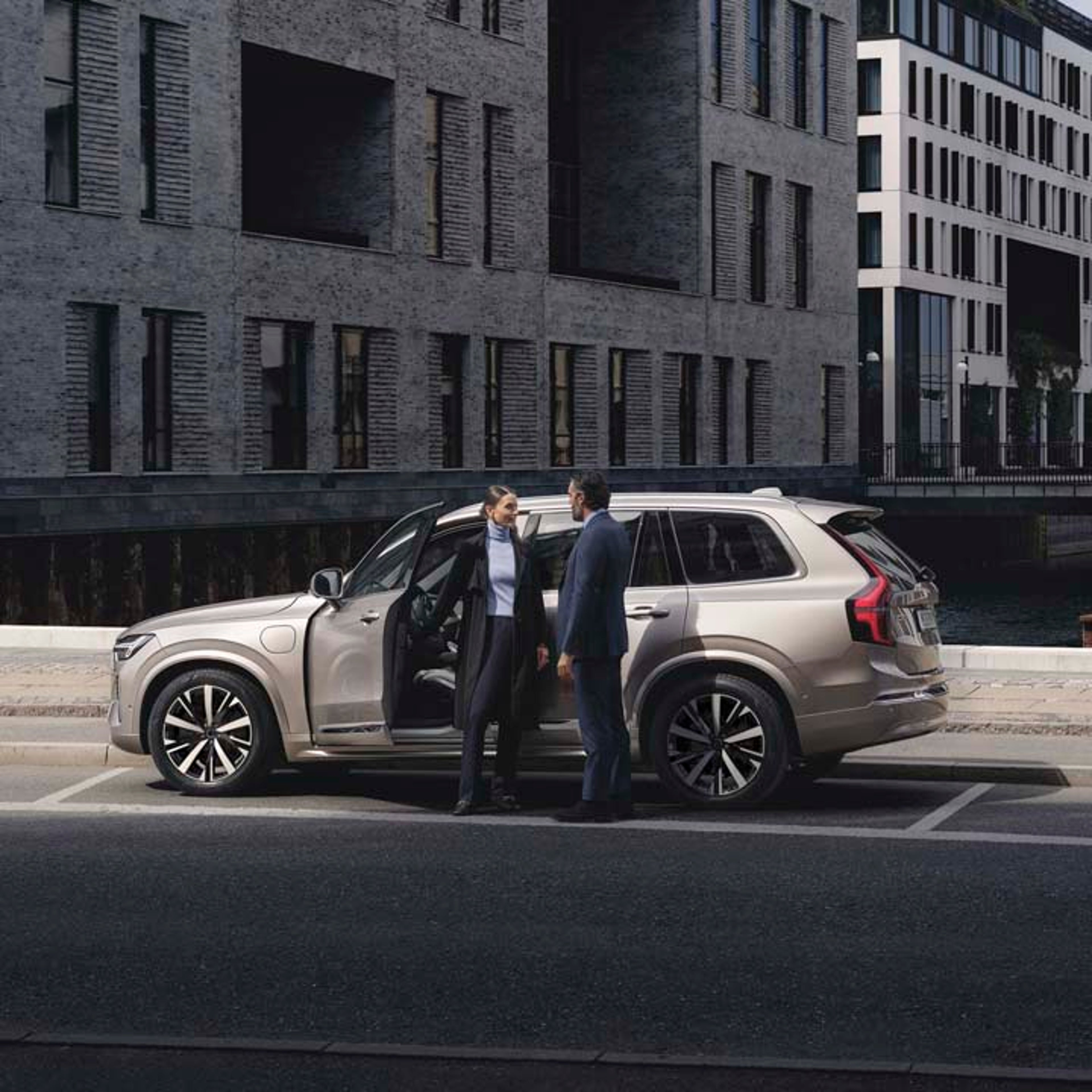 Volvo XC90 híbrido enchufable con dos personas hablando fuera del vehículo