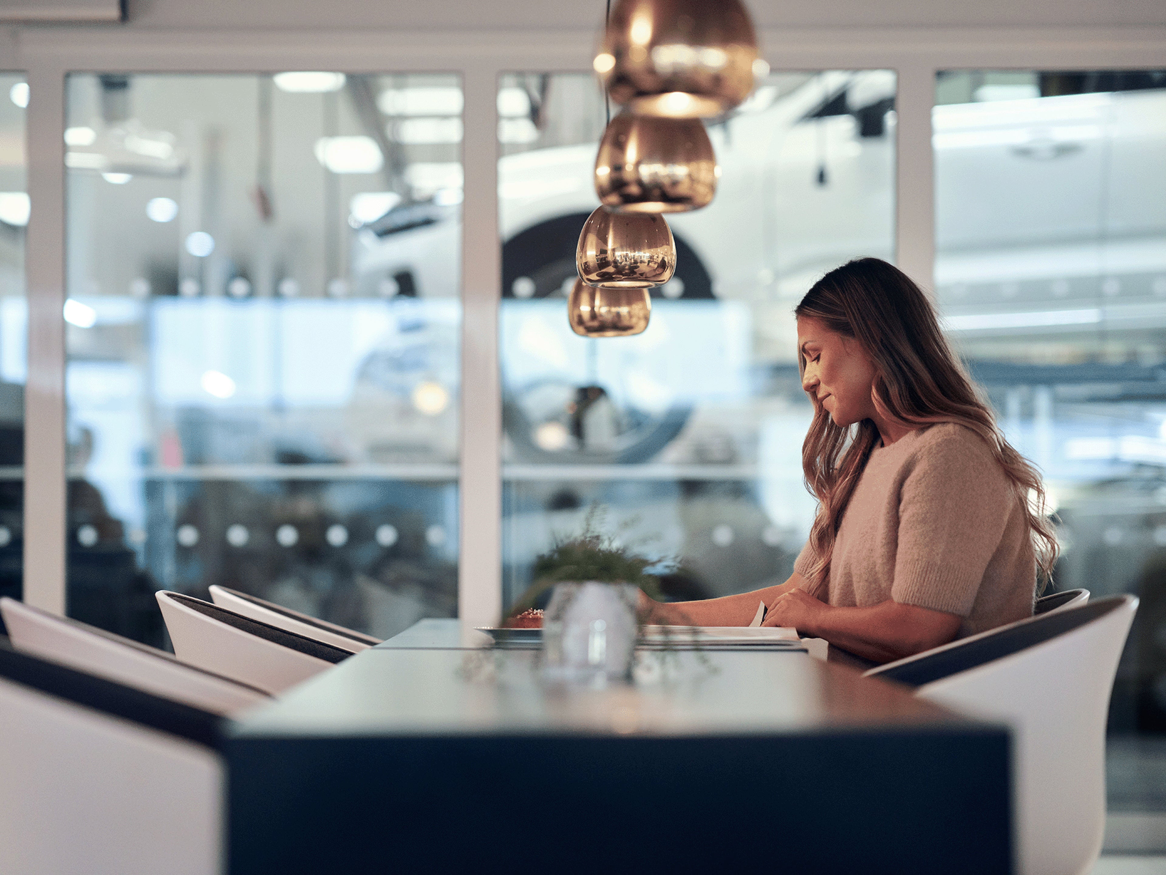 Eine Volvo Kundin sitzt an einem Tisch