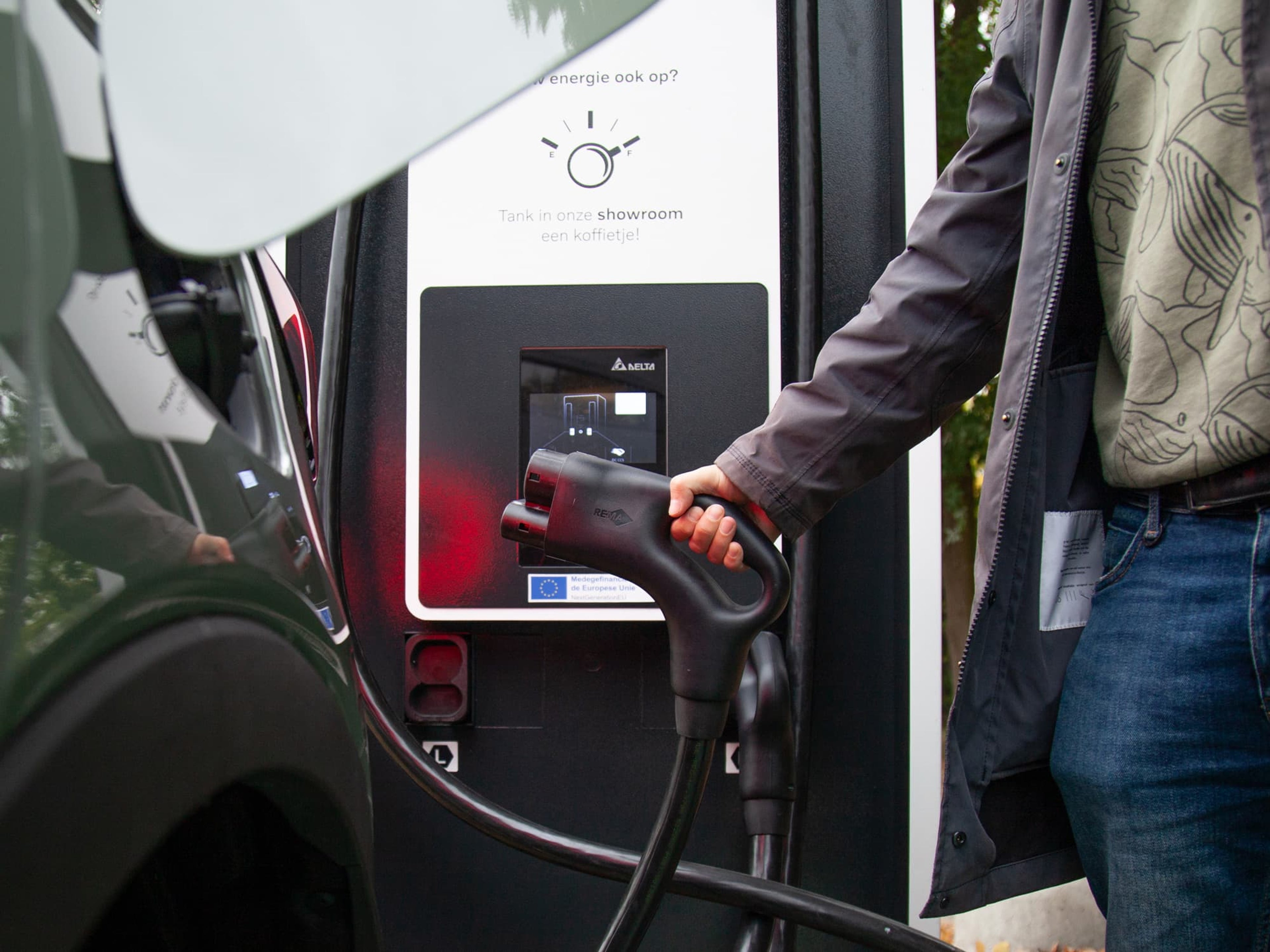 Iemand connecteert een oplaadkabel aan een oplaadstation.