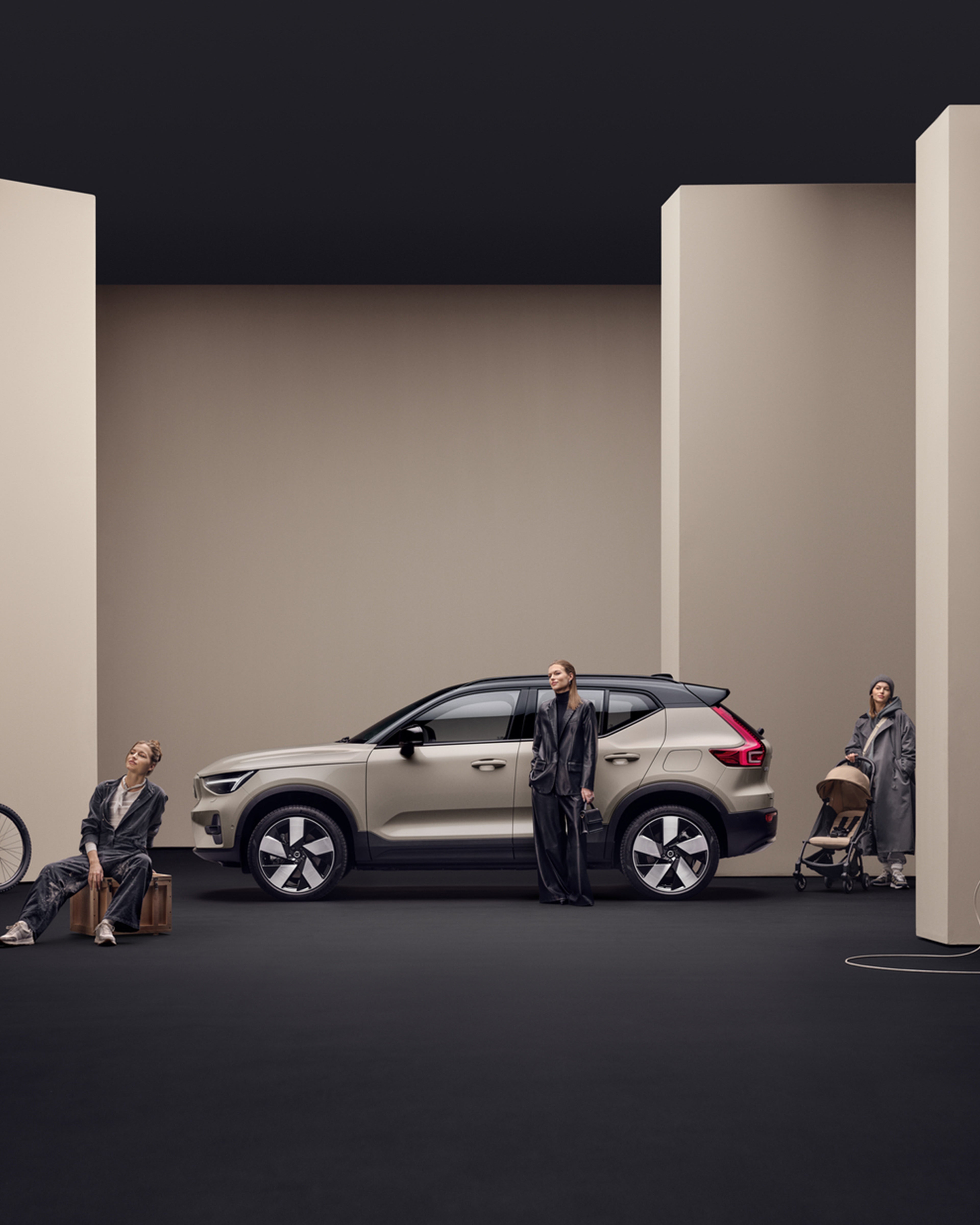 Hiekan sävyinen studiokuva Sand Dune -värisestä Volvo EX40 täyssähköisestä katumaasturista, jonka läheisyydessä sama nainen poseeraa viidellä erilaisella habituksella.