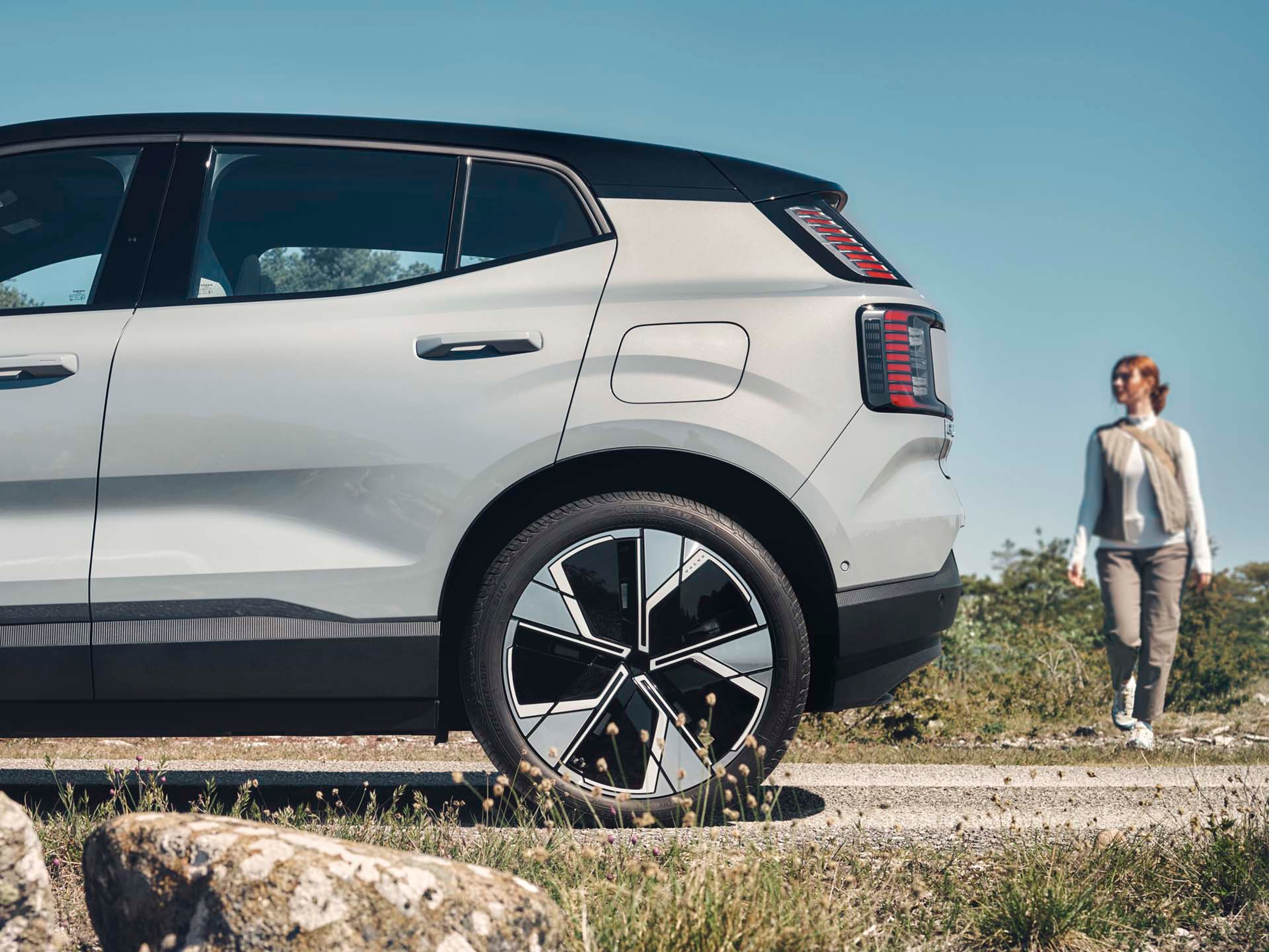 Una mujer andando hacia un Volvo EX30 eléctrico