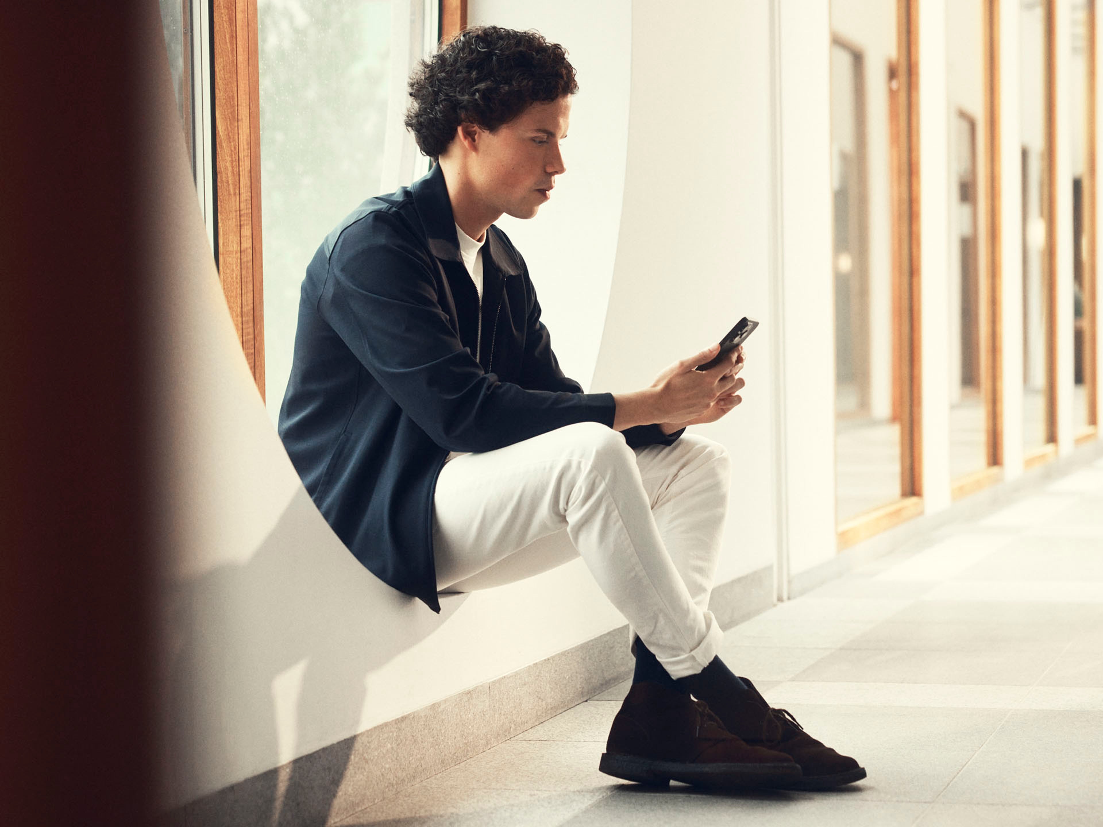 Un joven consultando y mirando un teléfono móvil