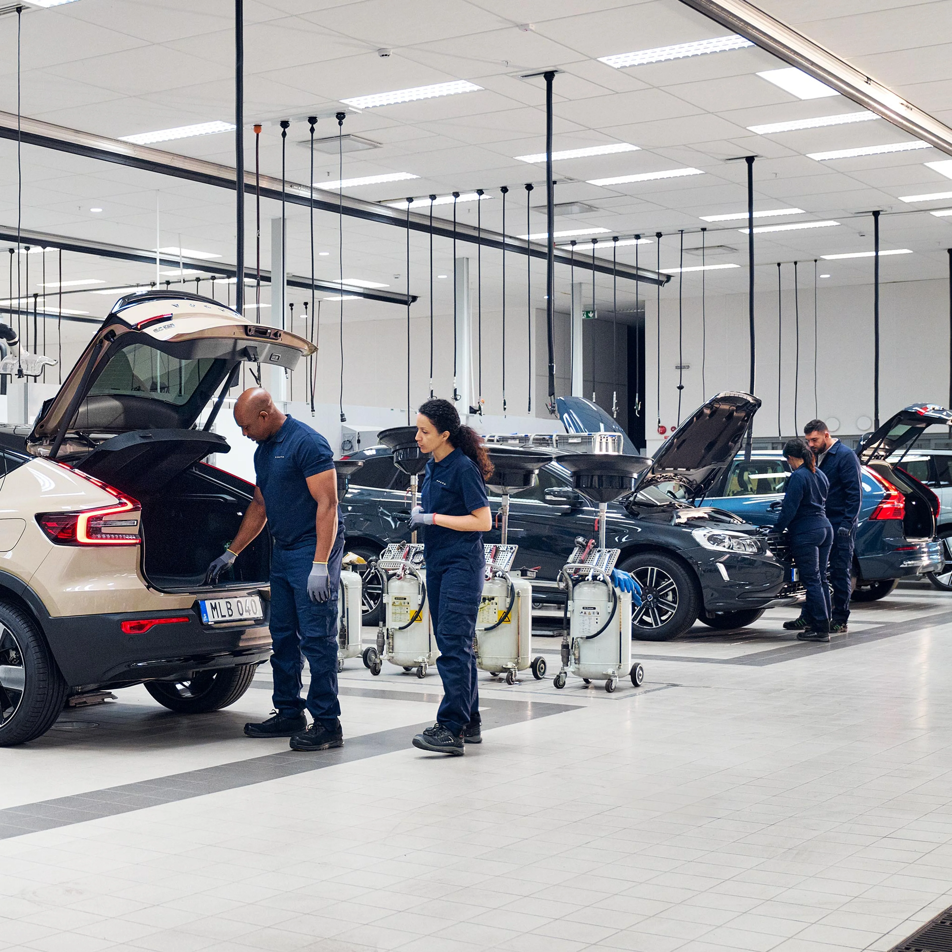 Volvo Omamekaanikot tutkivat eri mallisia Volvoja Volvo huoltoliikkeen tiloissa.