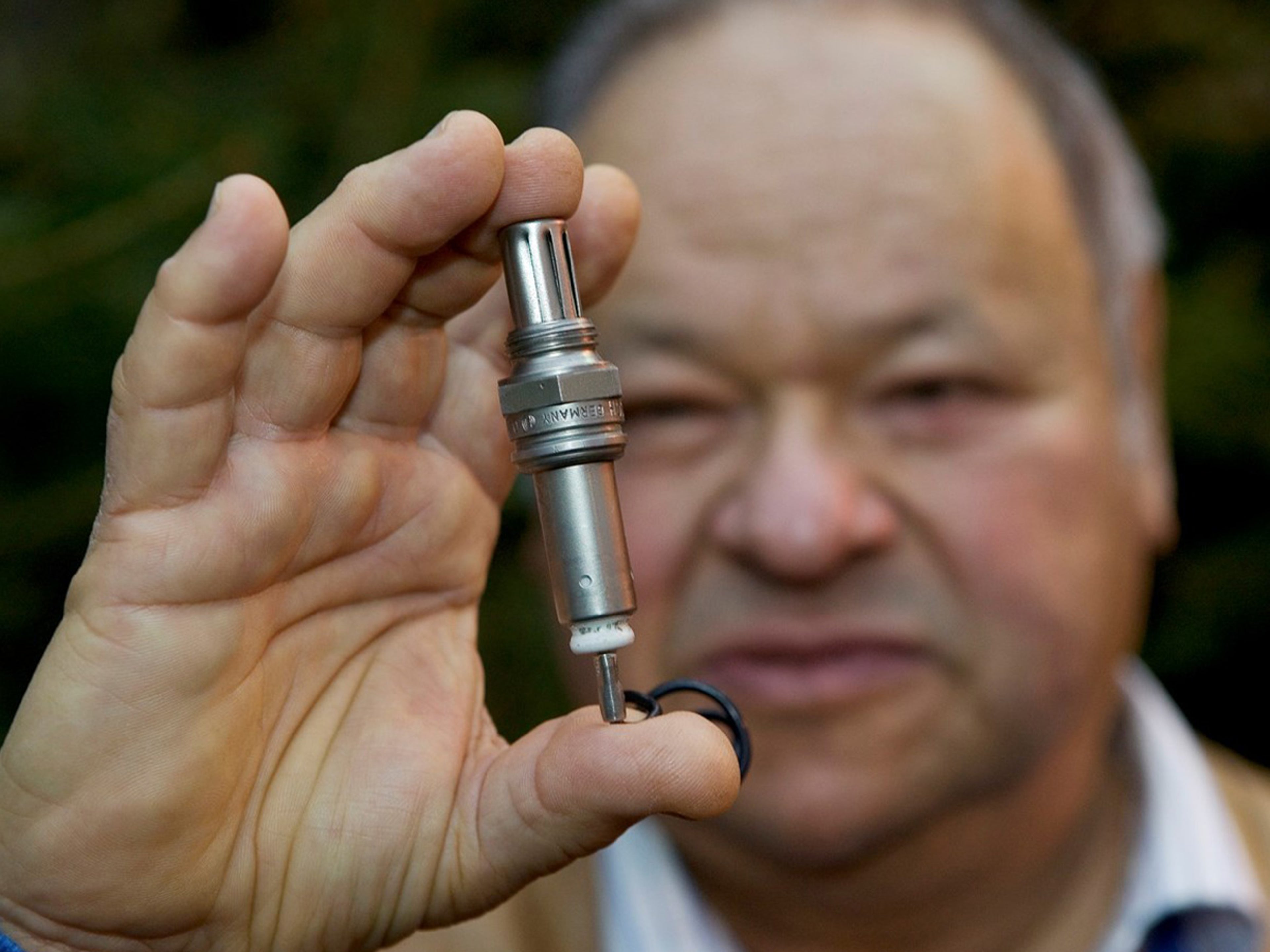 Up close image of man holding a Volvo Lambda sensor