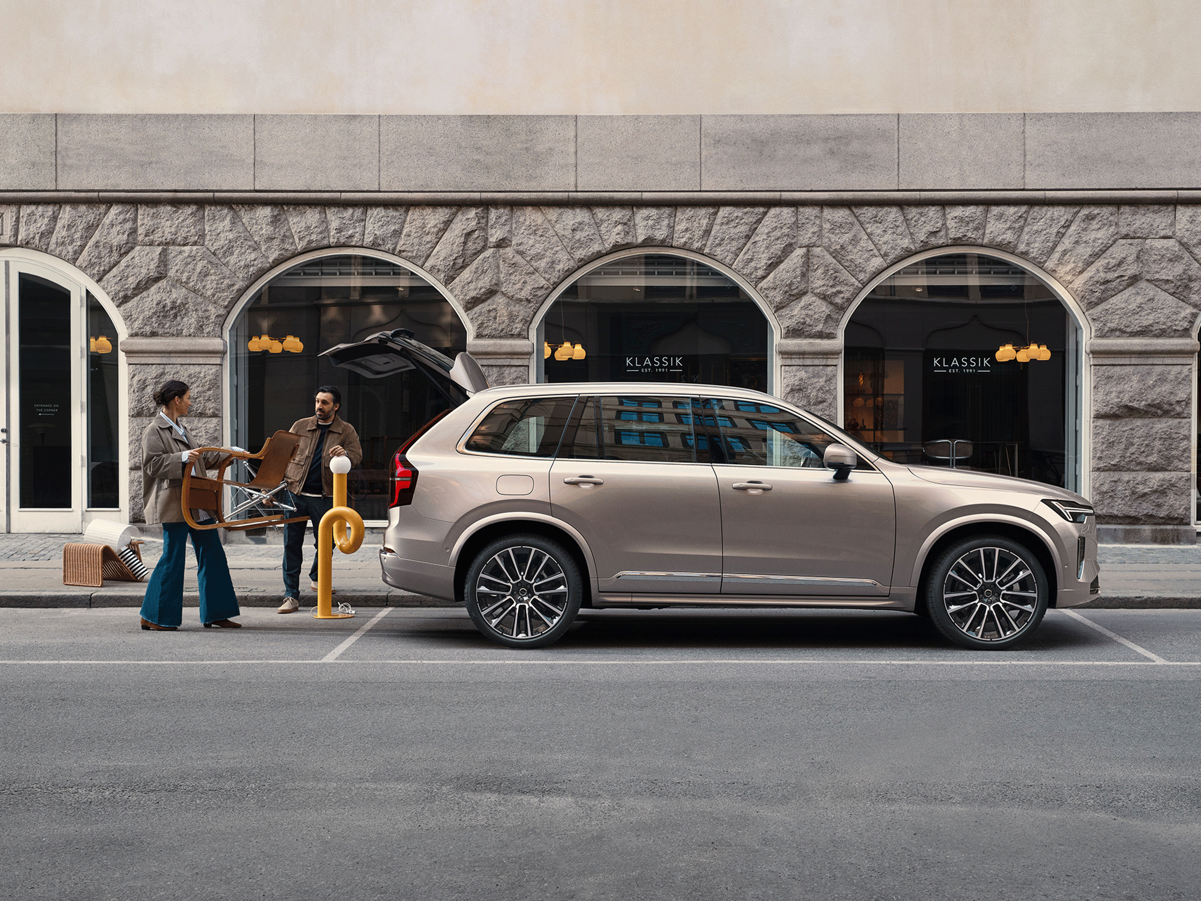 Zwei Personen räumen Möbel in einen geräumigen Volvo XC90.