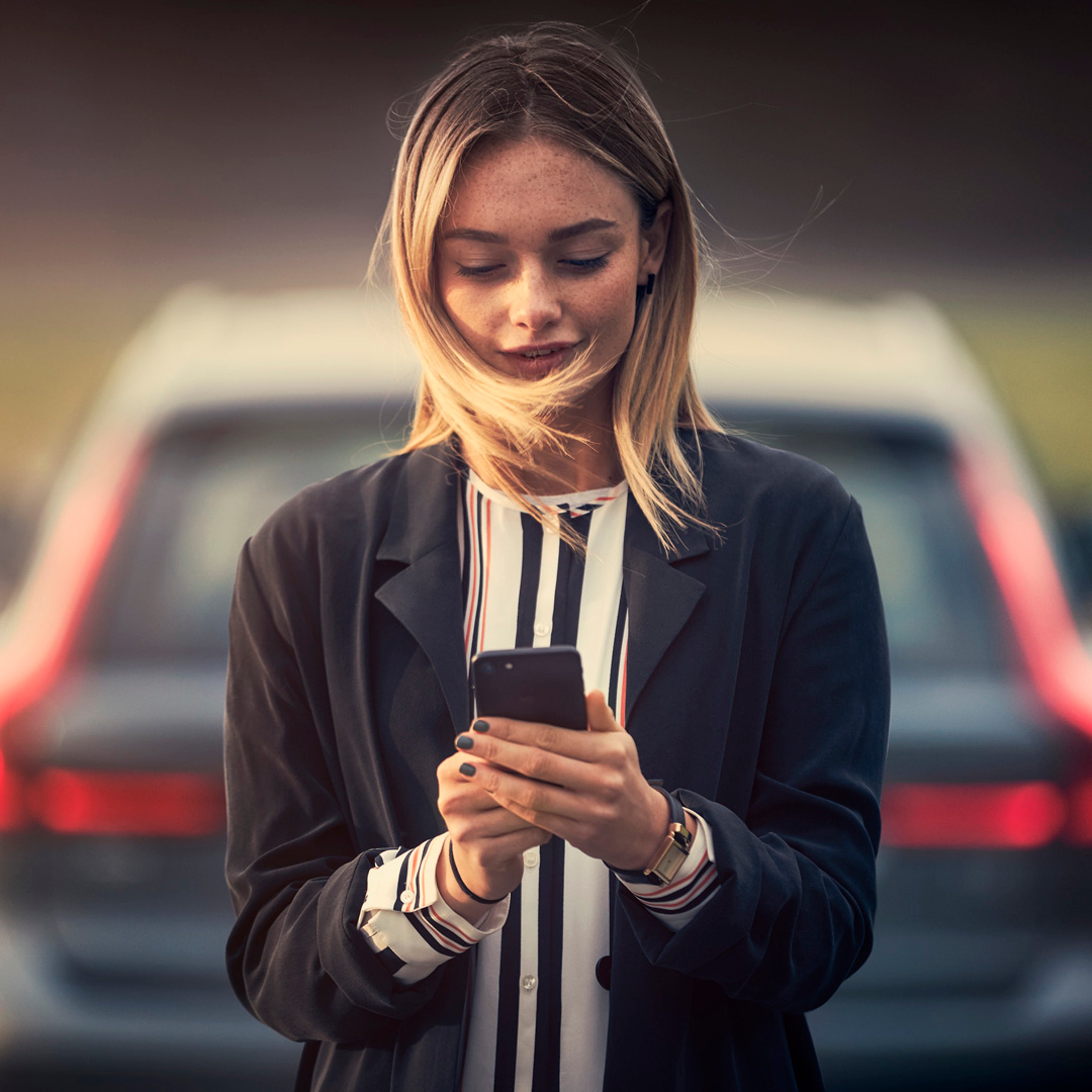 Mujer mirando la App Volvo Cars