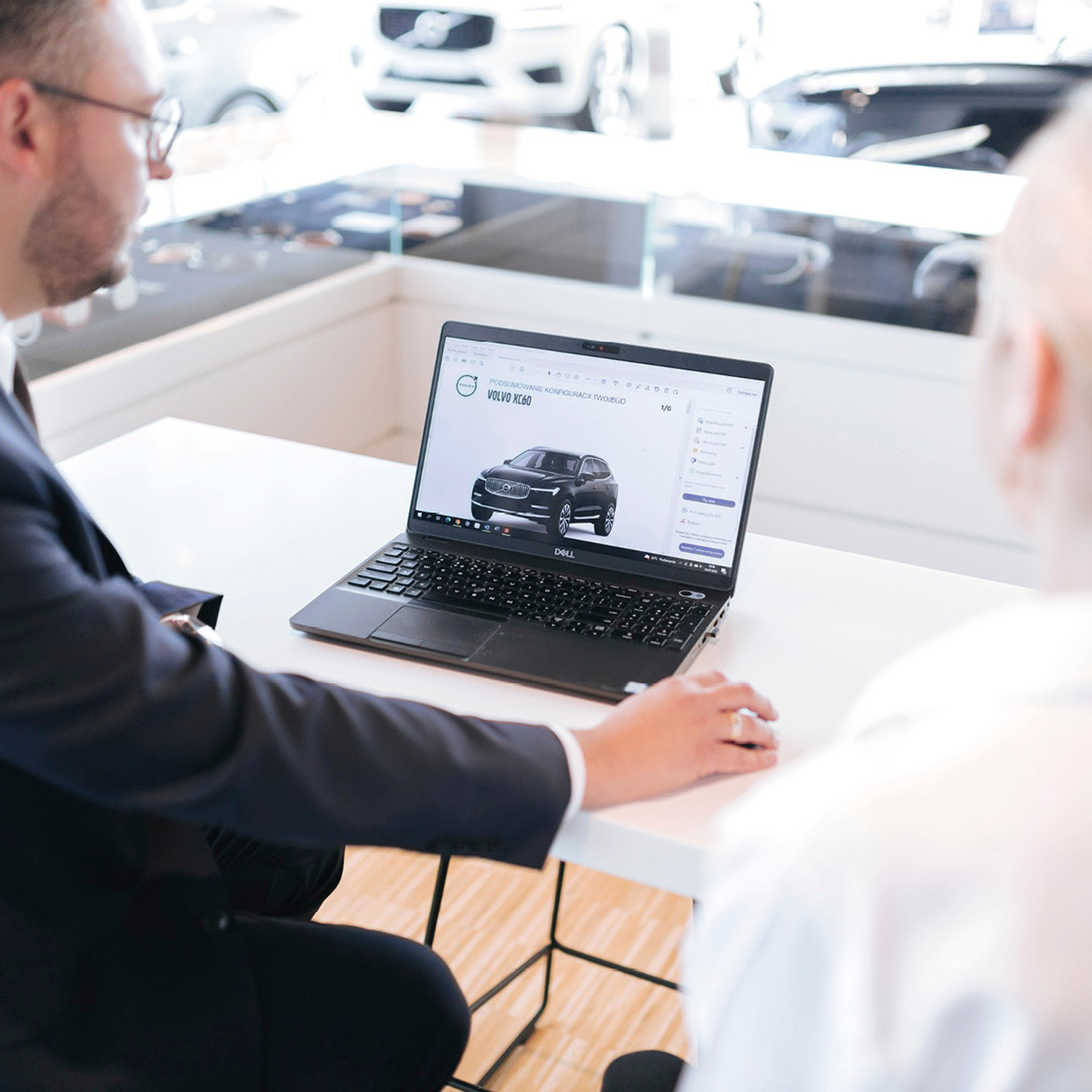 Pracownik biurowy przy laptopie na ekranie Volvo