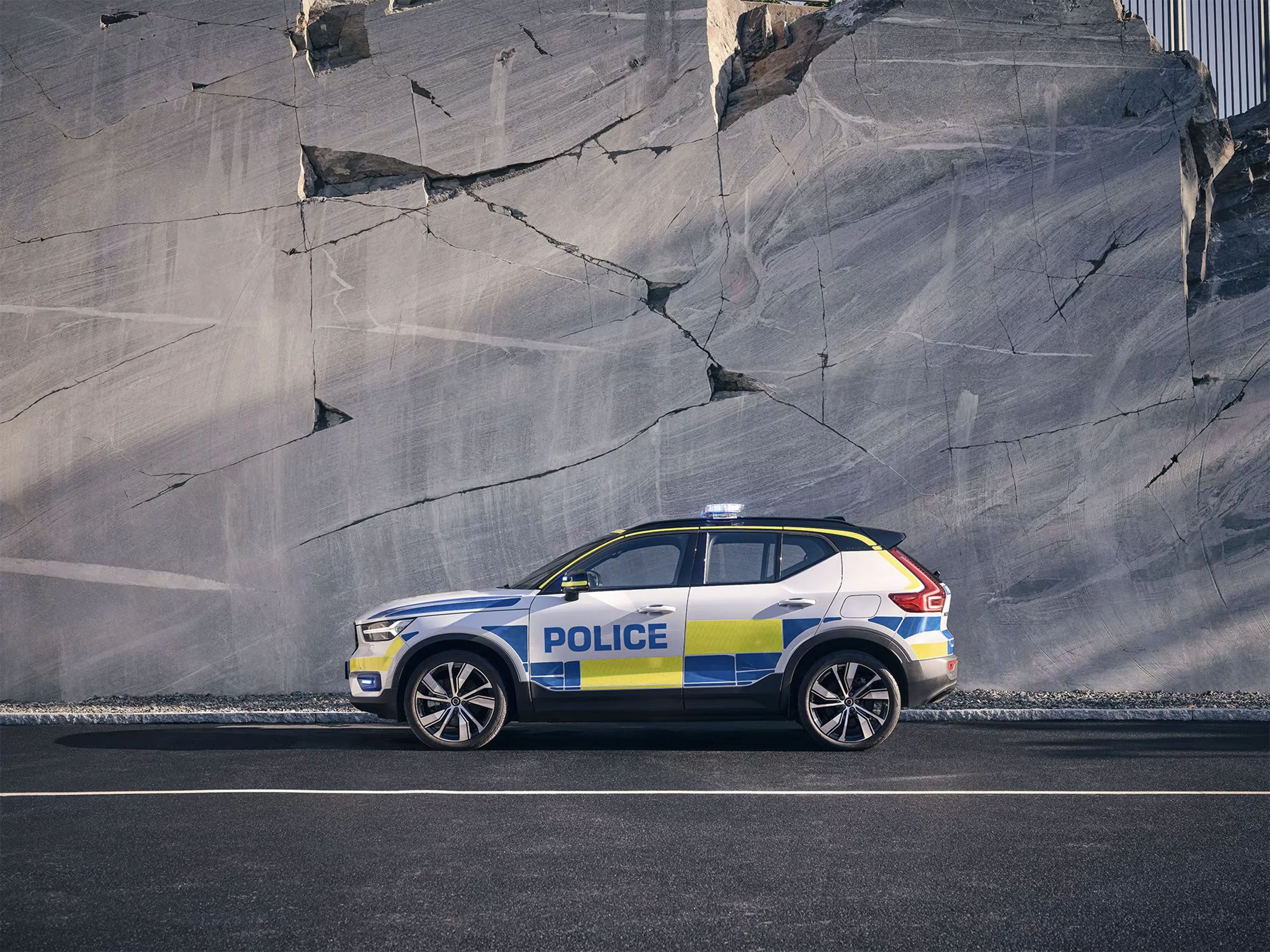 Volvo XC40 de police garée au bord d’une route, falaise rocheuse en arrière-plan