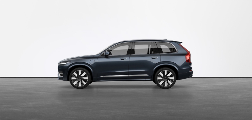 A dark grey Volvo XC90 Recharge plug-in hybrid SUV standing still on grey floor in a studio.