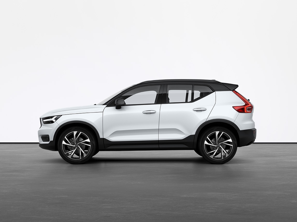 A crystal white Volvo XC40 compact SUV standing still on grey floor in a studio