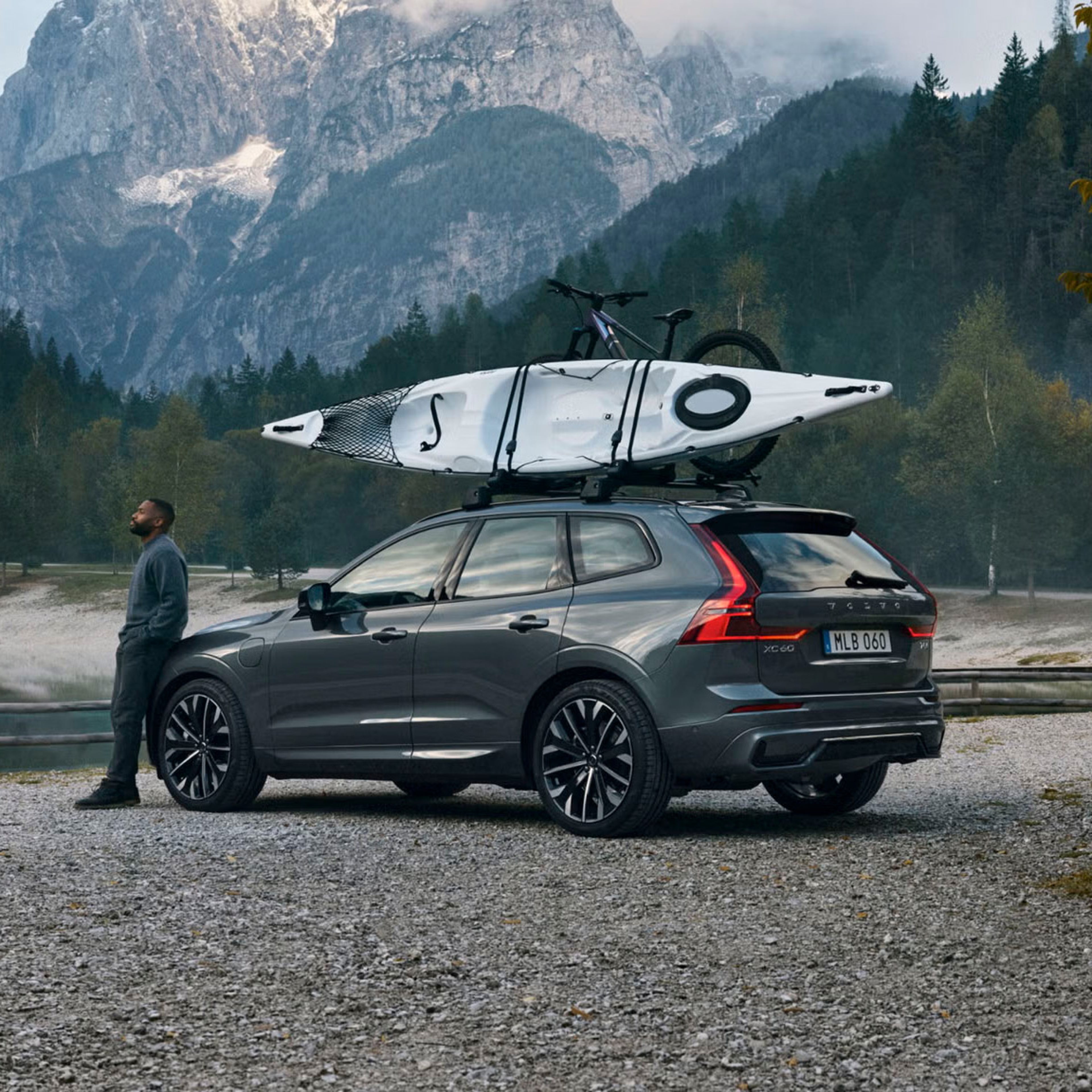 XC 60 parked in front of a striking mountain landscape with a kayak attached to the roof