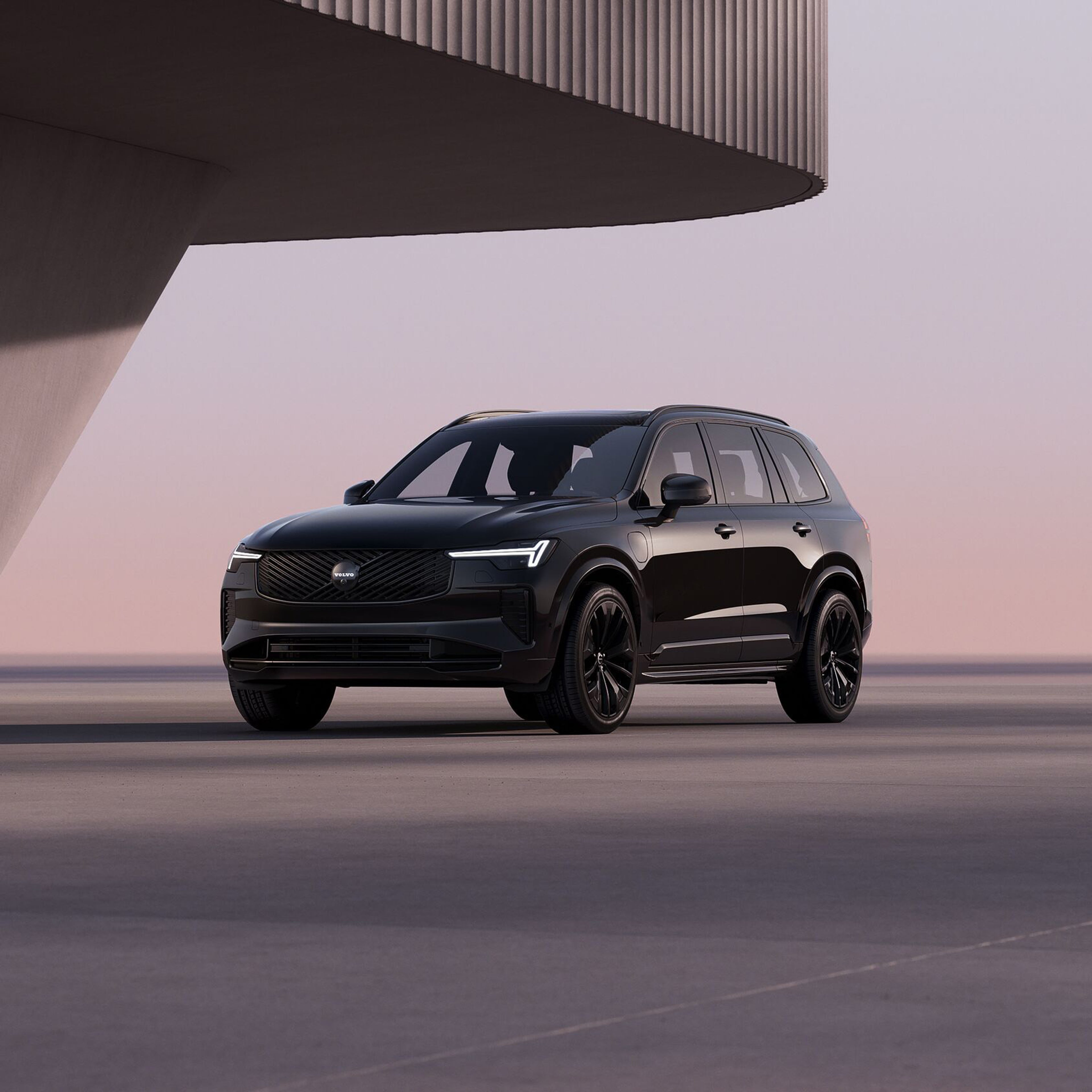 Side view of XC90 plug-in hybrid black edition with pink sunset colours in the background