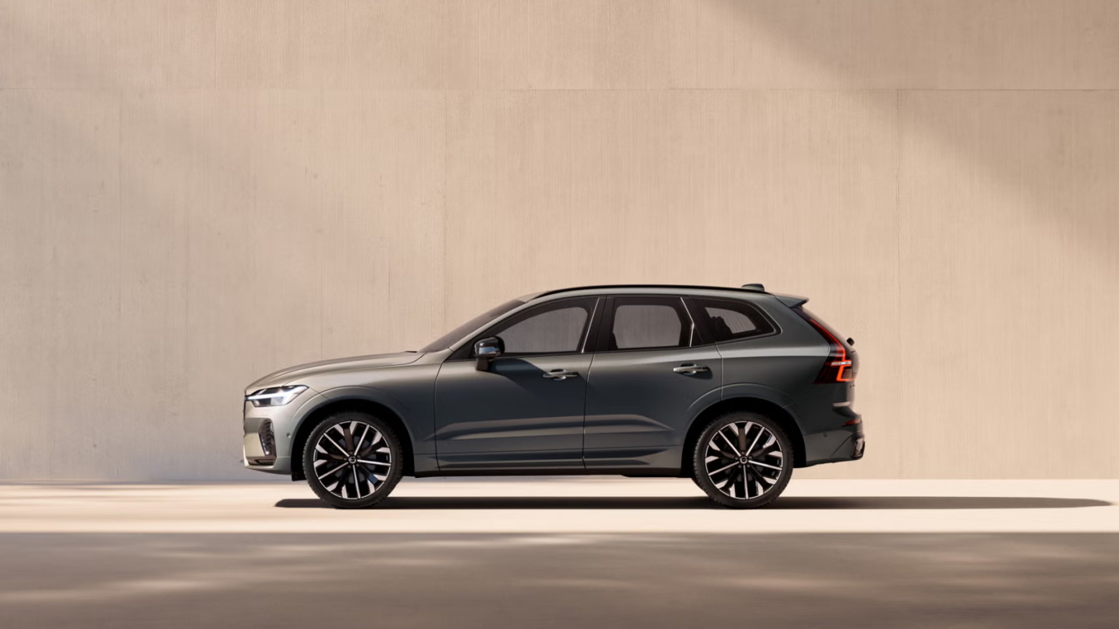 Side view of XC60 mild hybrid against pastel concrete background in daylight.