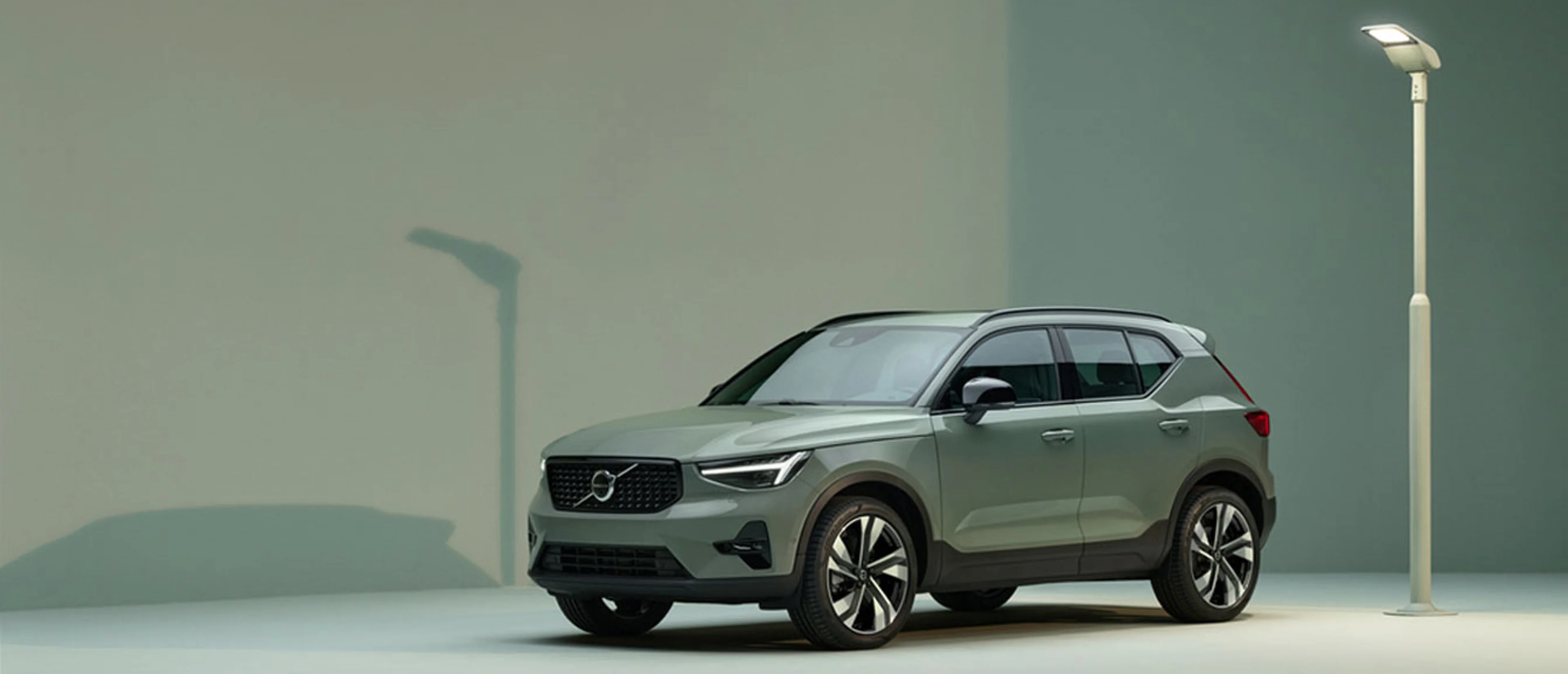 The side profile of a green Volvo XC40 SUV.