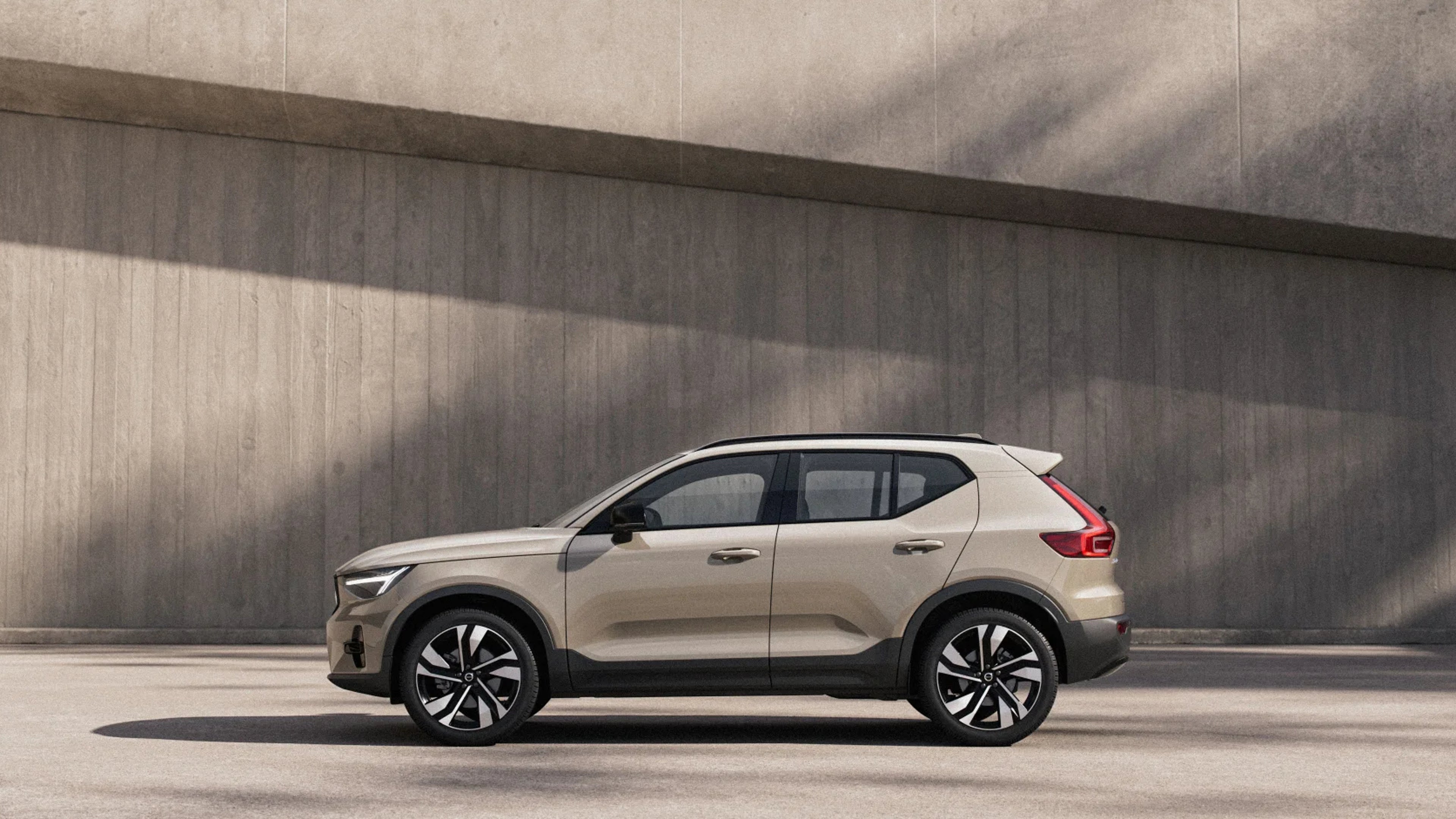 Side view of XC40 in daylight with concrete wall in the background
