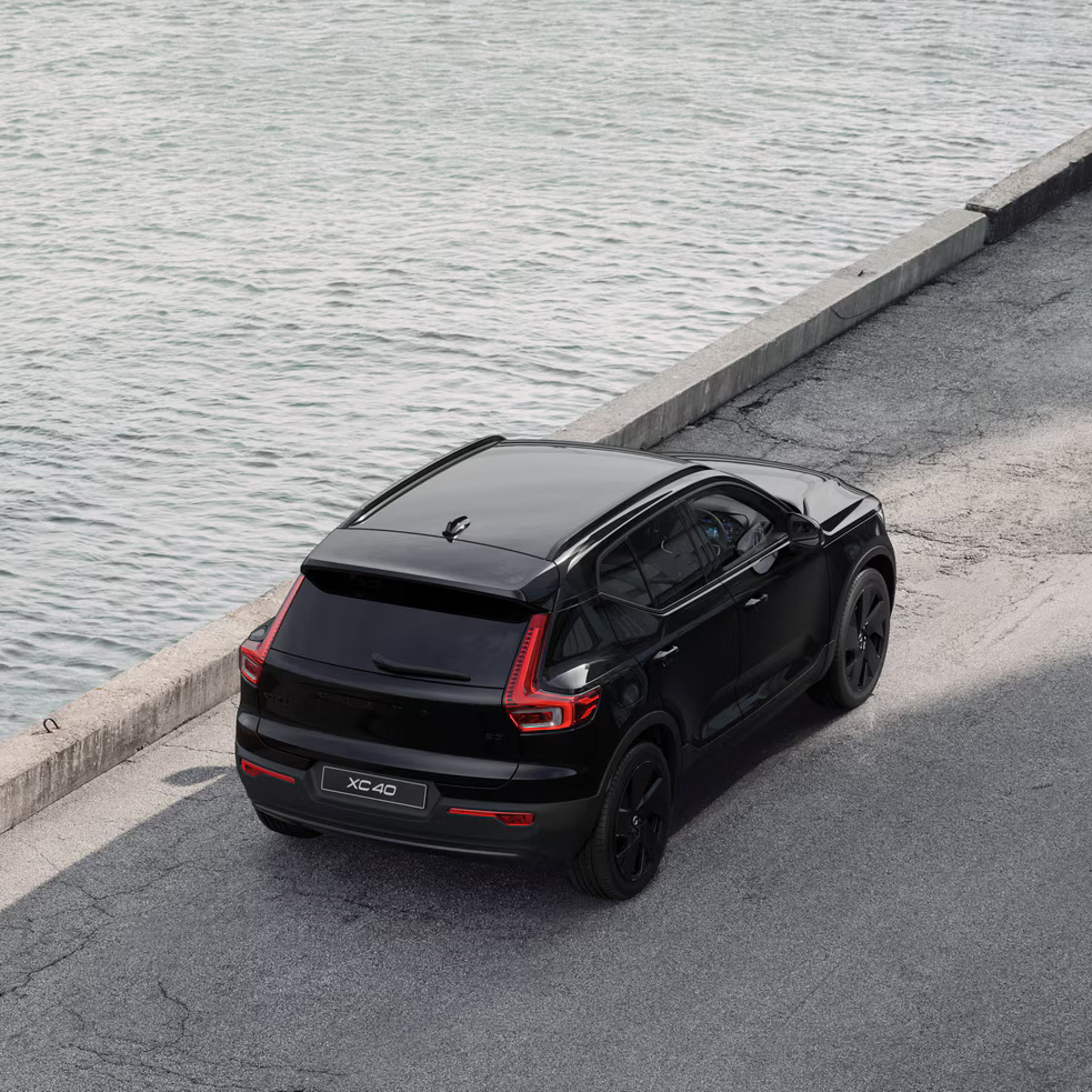 Rear view of XC40 black edition parked by a river