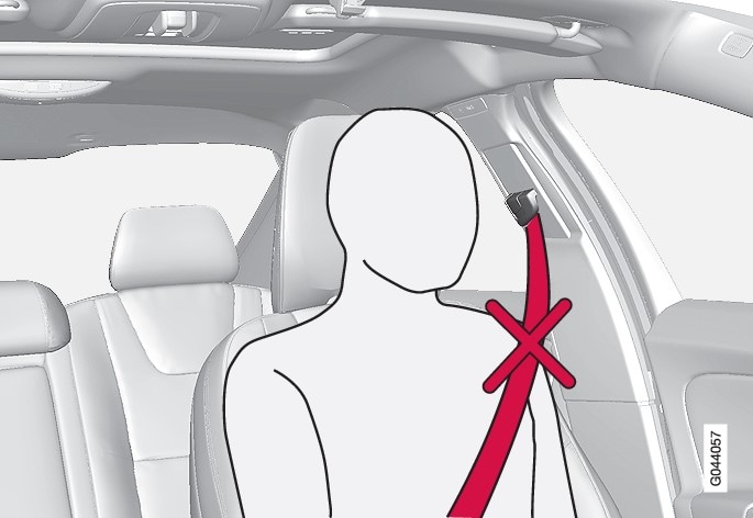 Cinturón de seguridad puesto de manera incorrecta. El cinturón debe ir sobre el hombro.