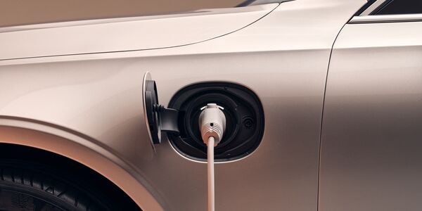 Close-up of an open charging port with the cable connected to a Volvo car.