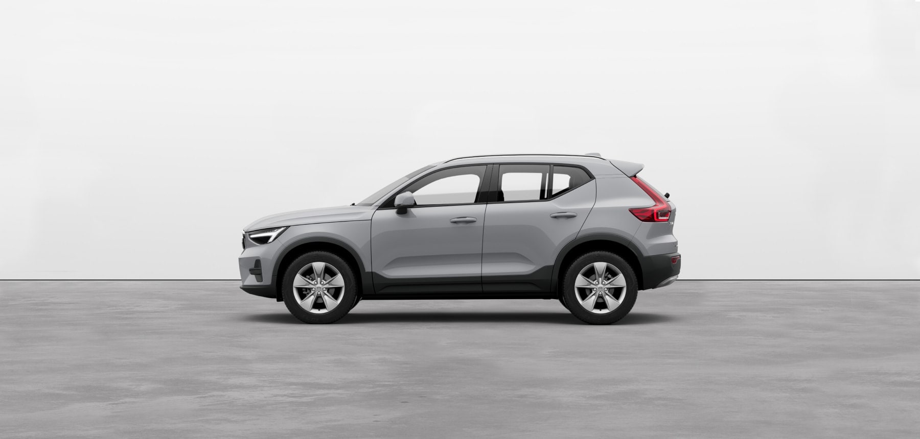 A vapour grey Volvo XC40 compact SUV standing still on grey floor in a studio