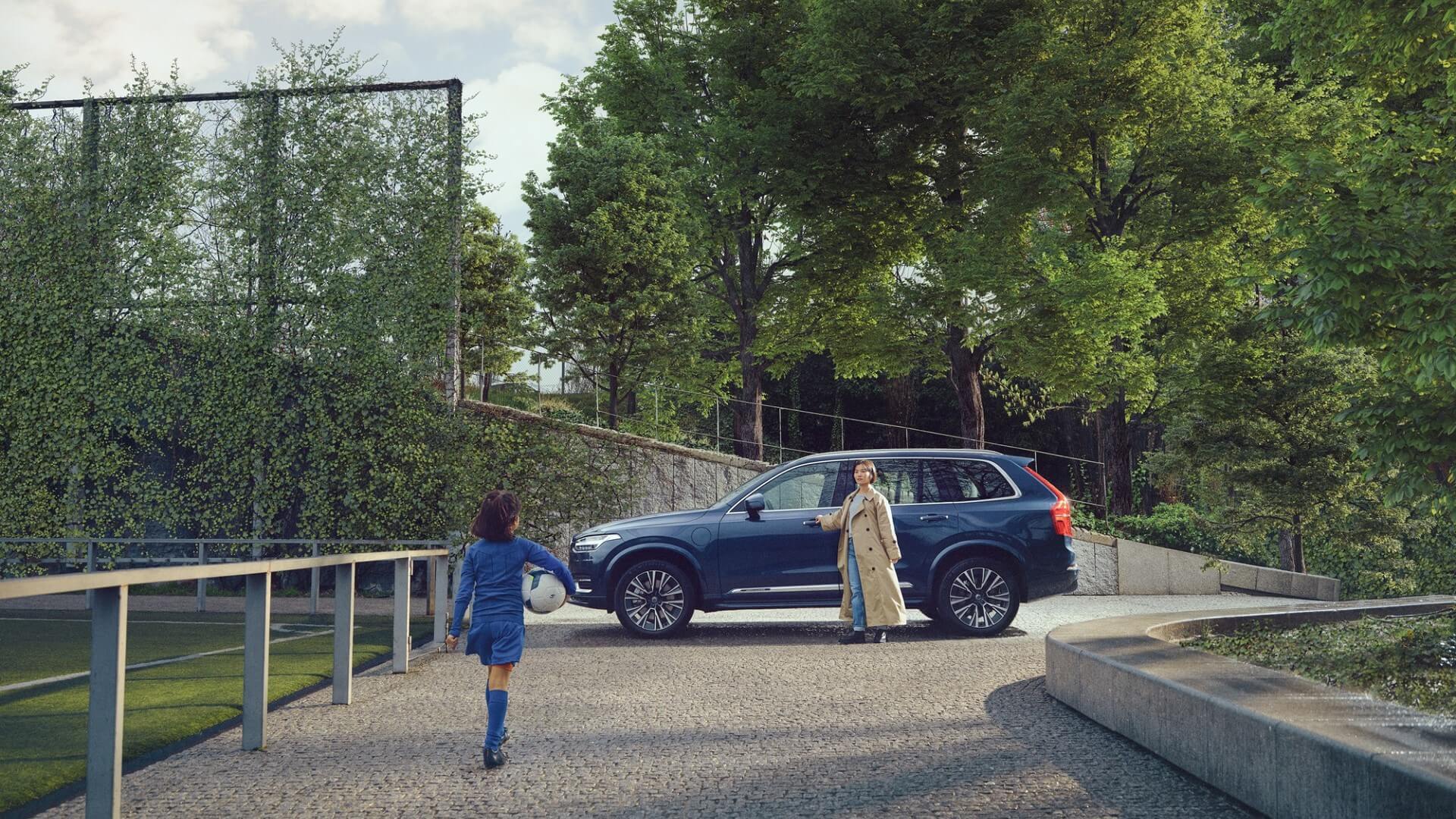 Young girl approaching her mother, who is standing next to XC90.