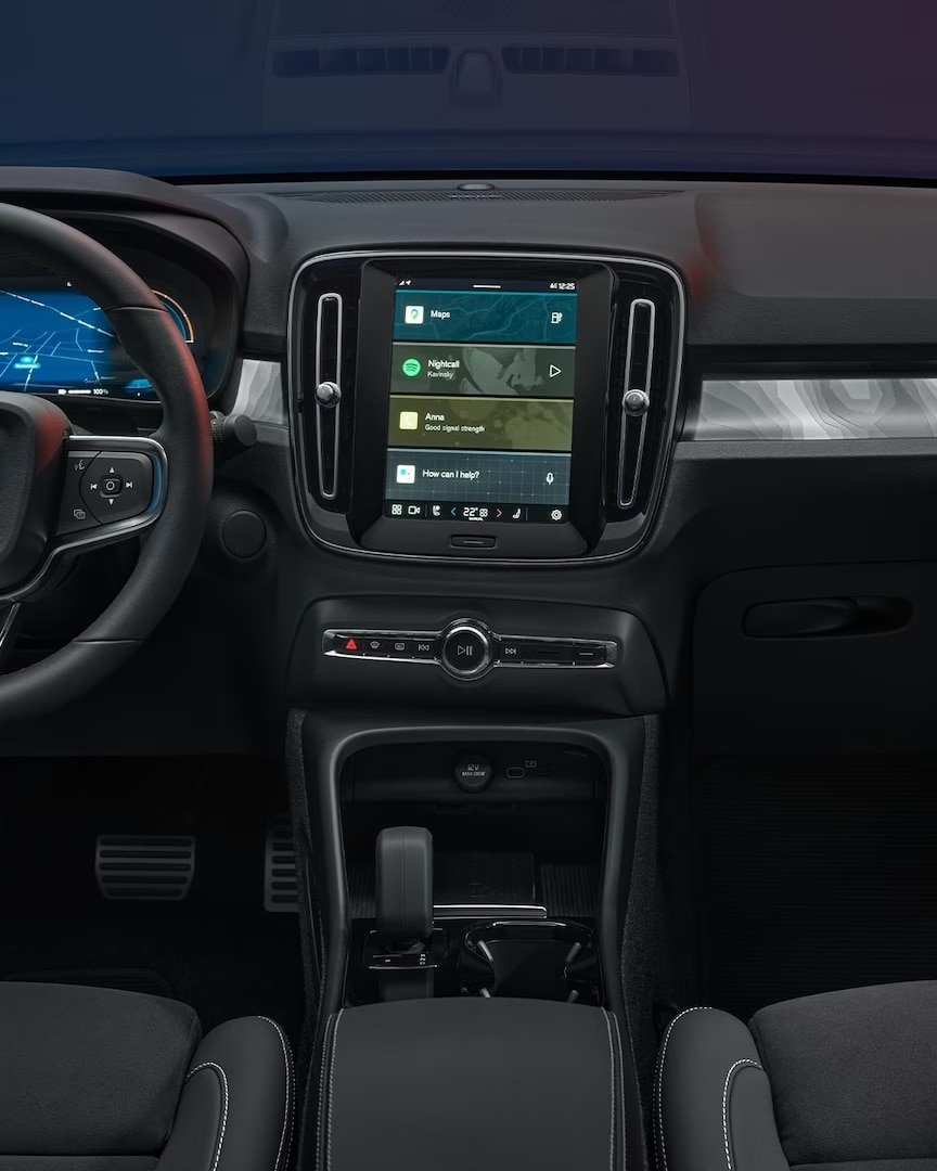 Vista interior de los asientos delanteros del Volvo C40 Recharge con volante, pantalla del conductor y pantalla central.