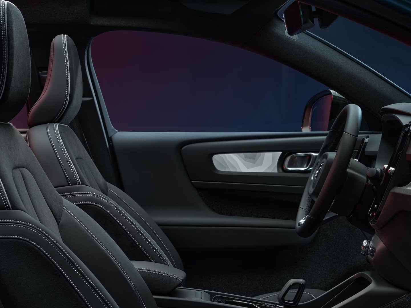 Vista interior de los asientos delanteros y el volante del Volvo C40 Recharge.