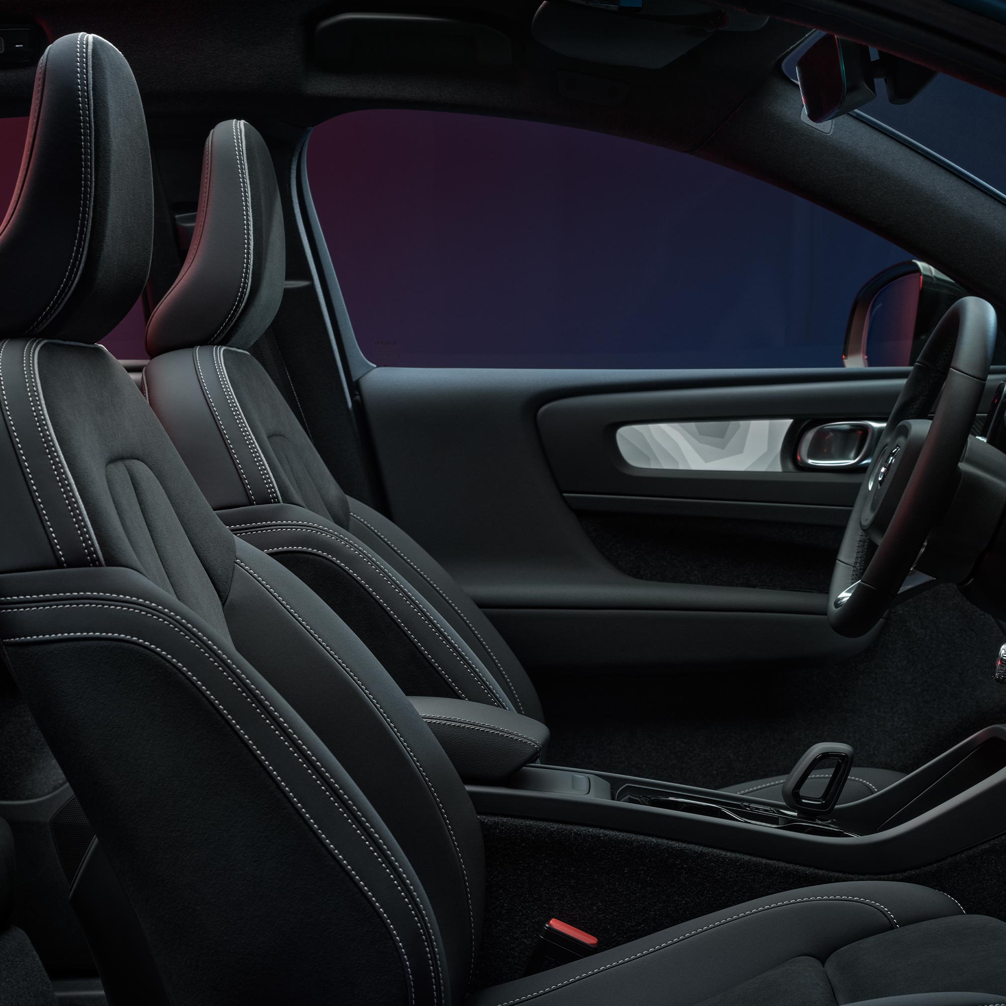 Volvo C40 Recharge'ın ön koltuklarının ve direksiyon simidinin iç görünümü.