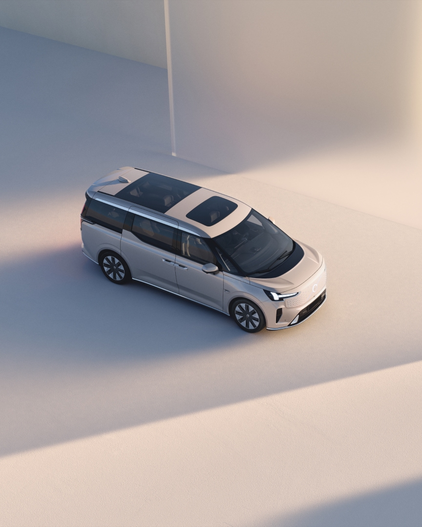 Wide-angle top-down view of the fully electric premium EM90 MPV in an abstract, neutral studio environment.