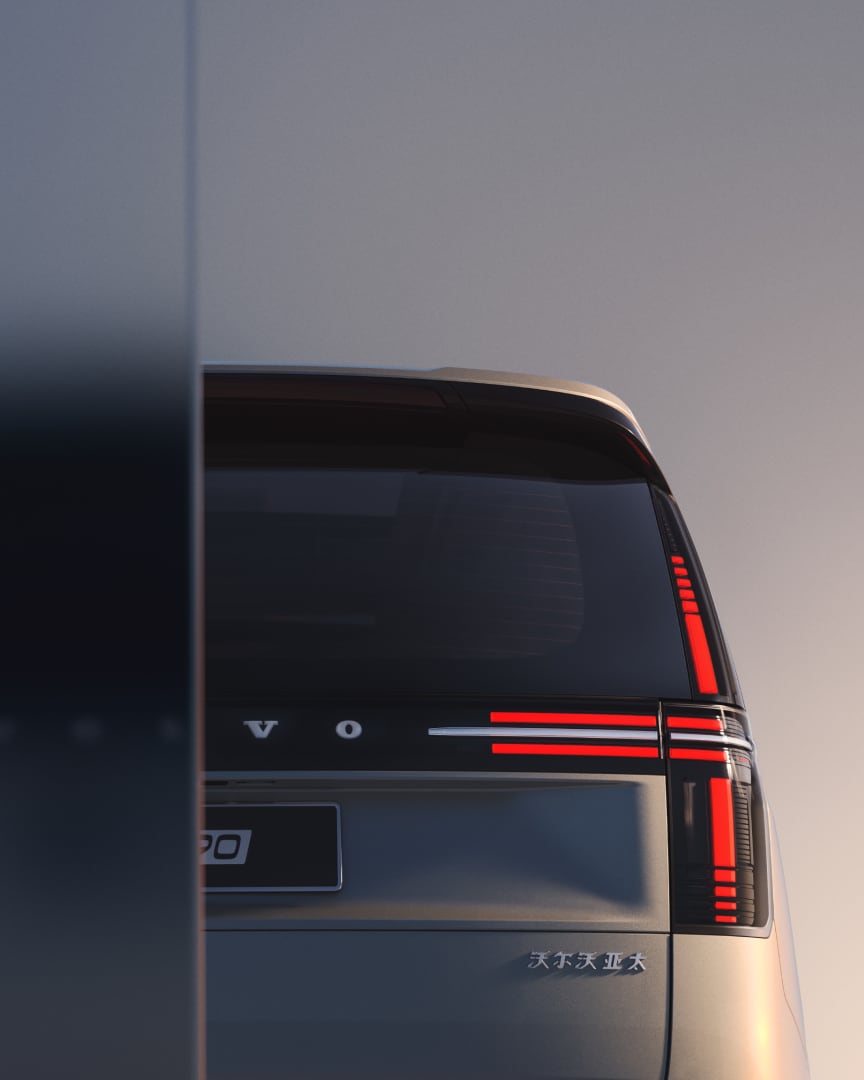 Close-up of Volvo Cars’ signature tail lights as they appear on the fully electric EM90, partly obscured by a glass wall.