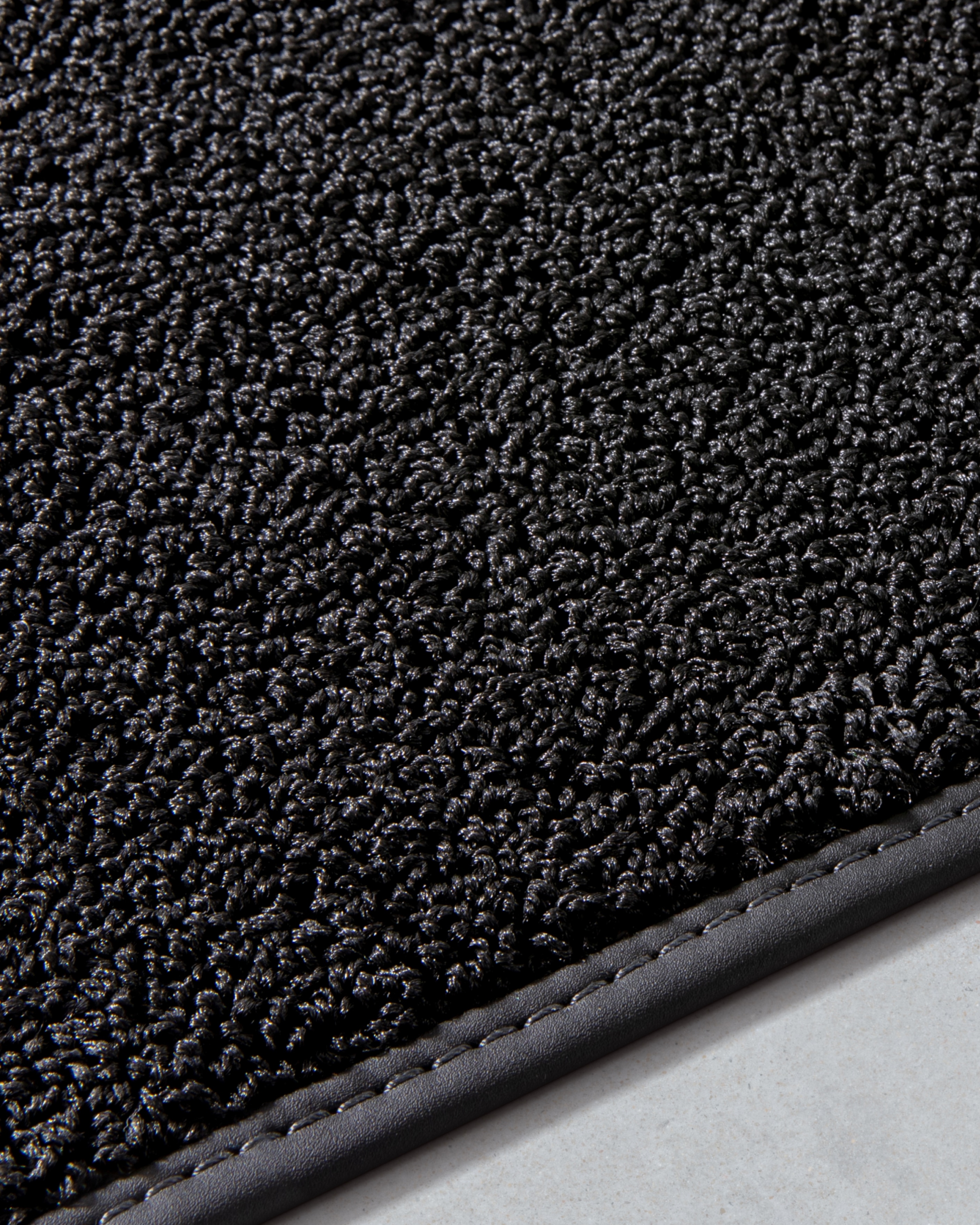 Image of the Volvo EX30's textile inlay mats made partially from fish net and inspired by rain drops.