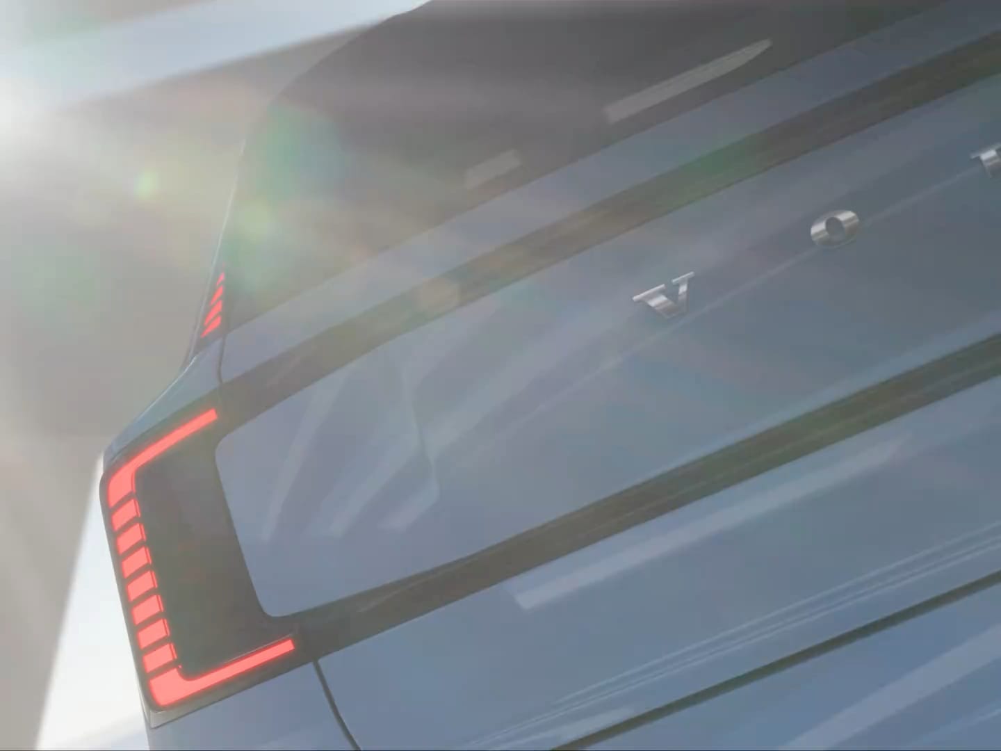 Die Rück- und Frontscheinwerfer eines fahrenden Volvo EX30, der von einer Leuchte auf dem Dach reflektiert wird.