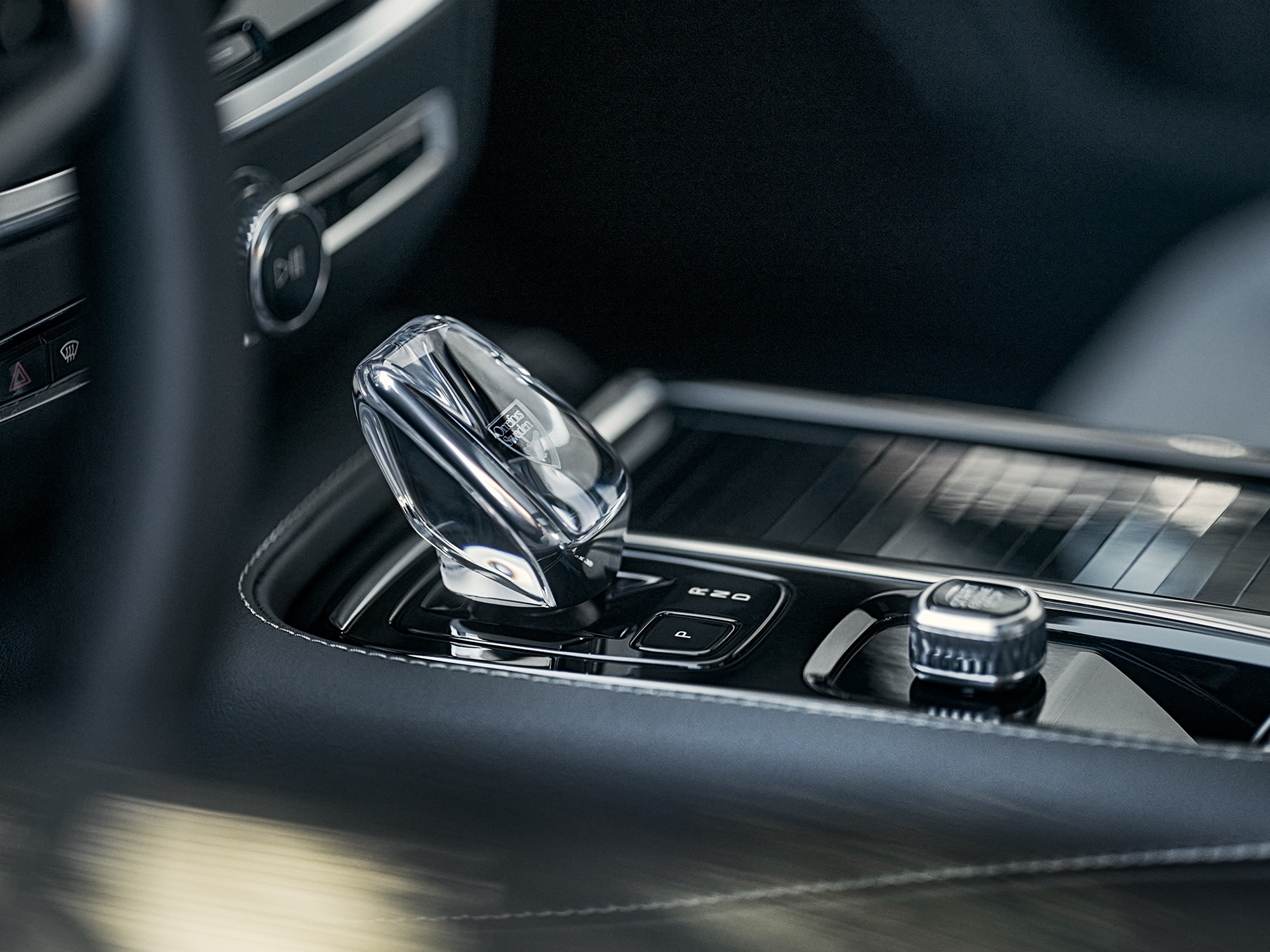 Botón de arranque y palanca de cambios de cristal en la consola central del Volvo S60 Recharge híbrido enchufable.
