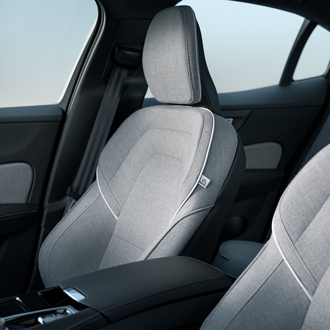 I sedili anteriori passeggero e guidatore della Volvo S60 Recharge Plug-in Hybrid con rivestimento sartoriale in misto lana grigia e finitura bianca.