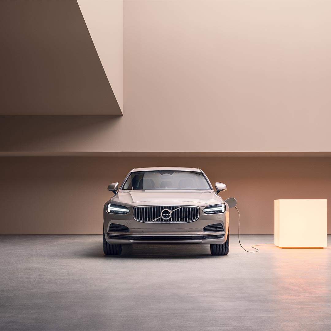 Front view image of a Volvo S90 Plug-in hybrid charging from a light box.