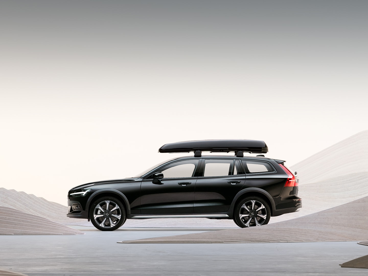The side profile of a Volvo V60 Cross Country wagon with a roof box.
