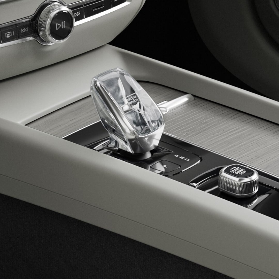 Botón de arranque y palanca de cambios de cristal en la consola central con acabados en madera del semihíbrido Volvo V60.