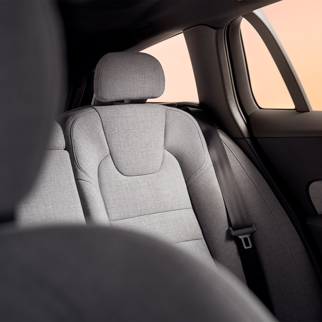 Rear passenger seat in grey Tailored Wool Blend upholstery and seat belt in the Volvo V60 Recharge plug-in hybrid.