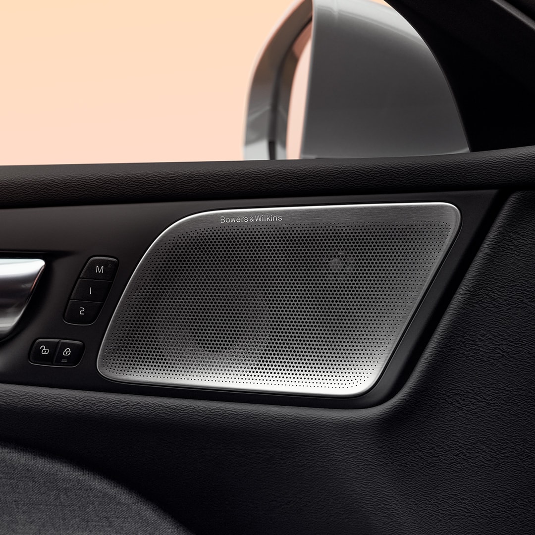 Close-up of a Bowers & Wilkins door speaker and passenger controls in the Volvo V60 Recharge plug-in hybrid.