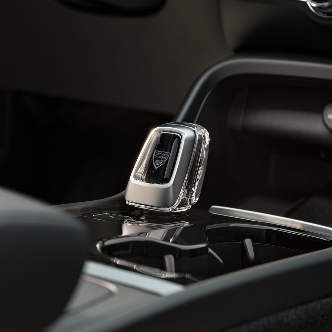 Рукоятка перемикача передач із кришталю на чорній центральній консолі повністю електричного Volvo XC40 Recharge, крупний план.