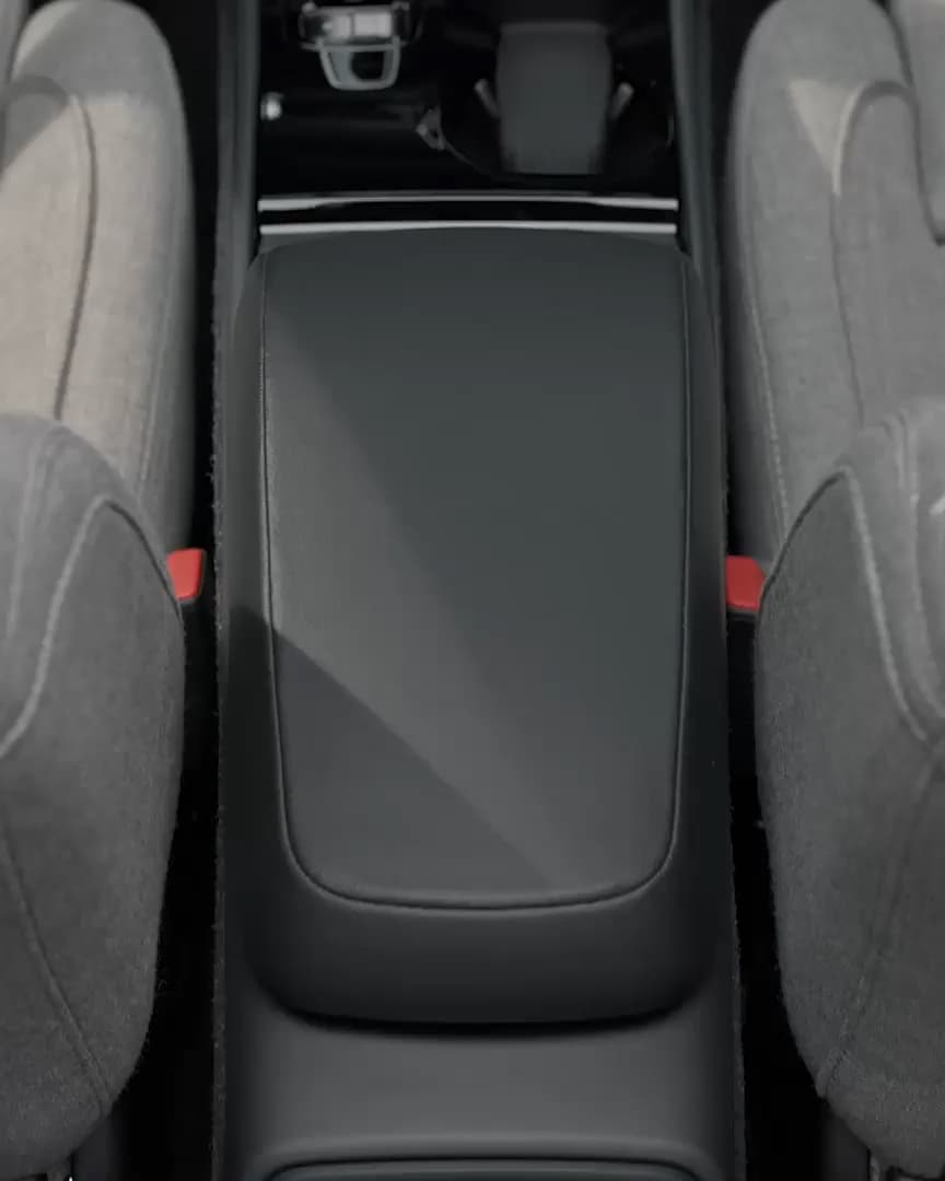 Center console armrest bin lid between upholstered front passenger and driver’s seats in the Volvo XC40 Recharge pure electric.