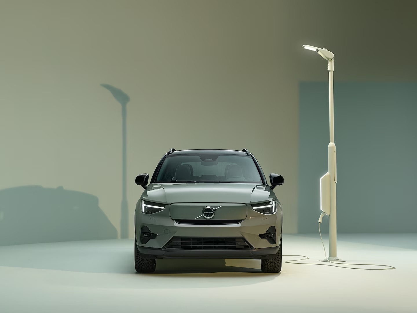 Volvo XC40 Recharge pure electric exterior front design with charger and charging station.