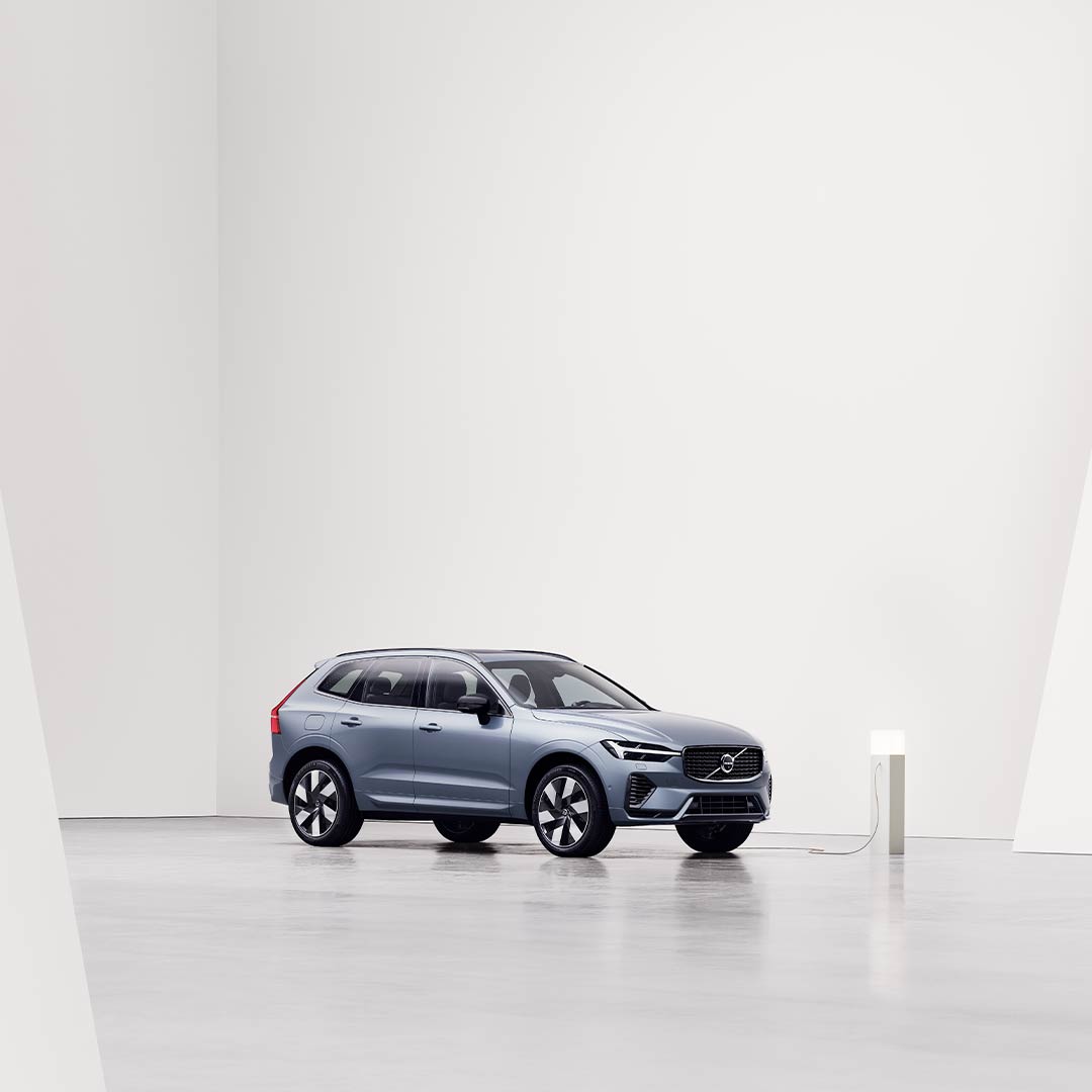 Side view of the gray Volvo XC60 Recharge being charged at charging station.