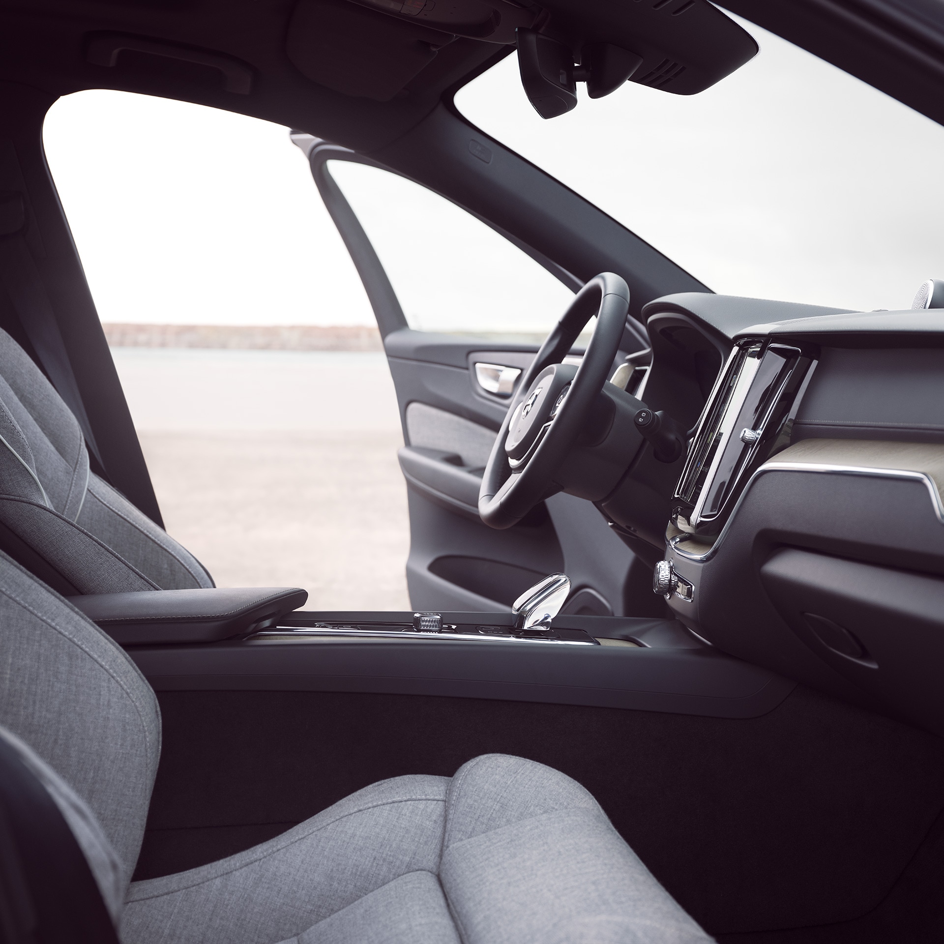 Interior frontal del Volvo XC60 Recharge con la puerta del conductor abierta.