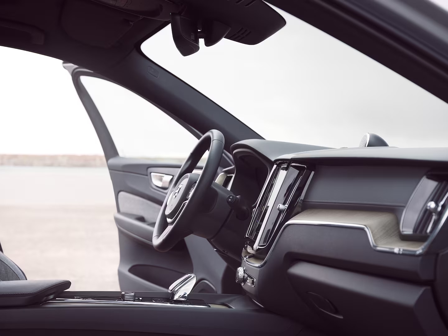 Interior delantero del Volvo XC60 Recharge, con la puerta del conductor abierta.