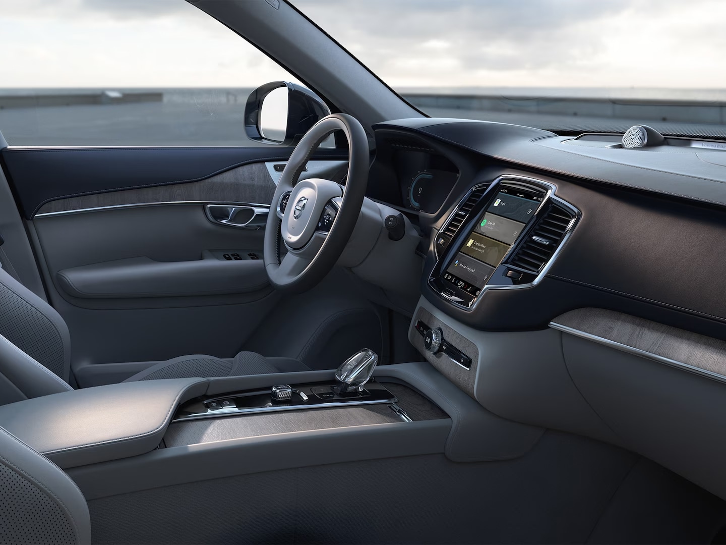 Asiento del conductor y revestimiento de las puertas en cuero napa, volante, consola central y pantalla táctil de infoentretenimiento en el XC90 semihíbrido.