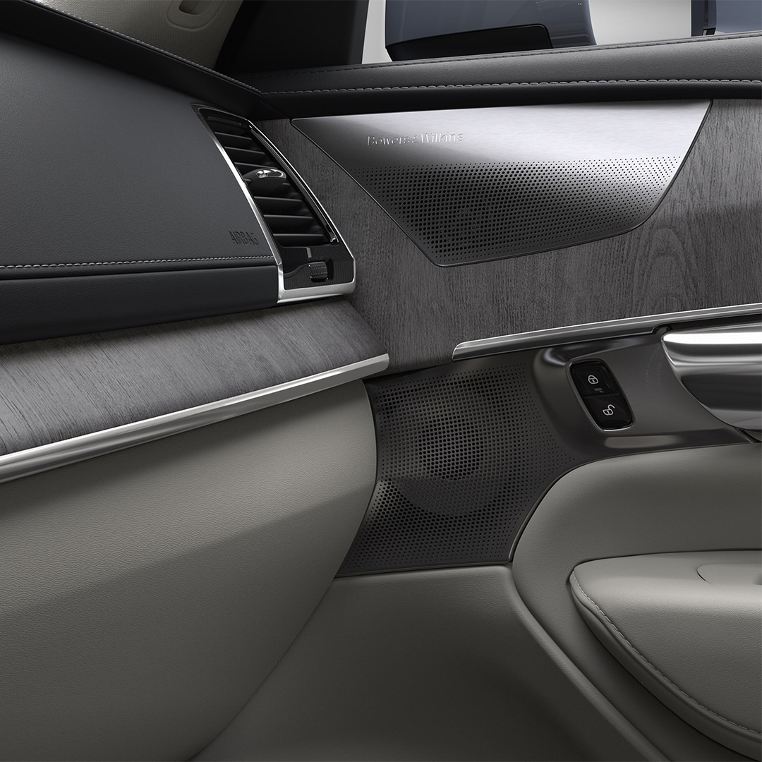 Salpicadero del lado del pasajero tapizado en negro y beige con decoración de madera en el SUV semihíbrido Volvo XC90.